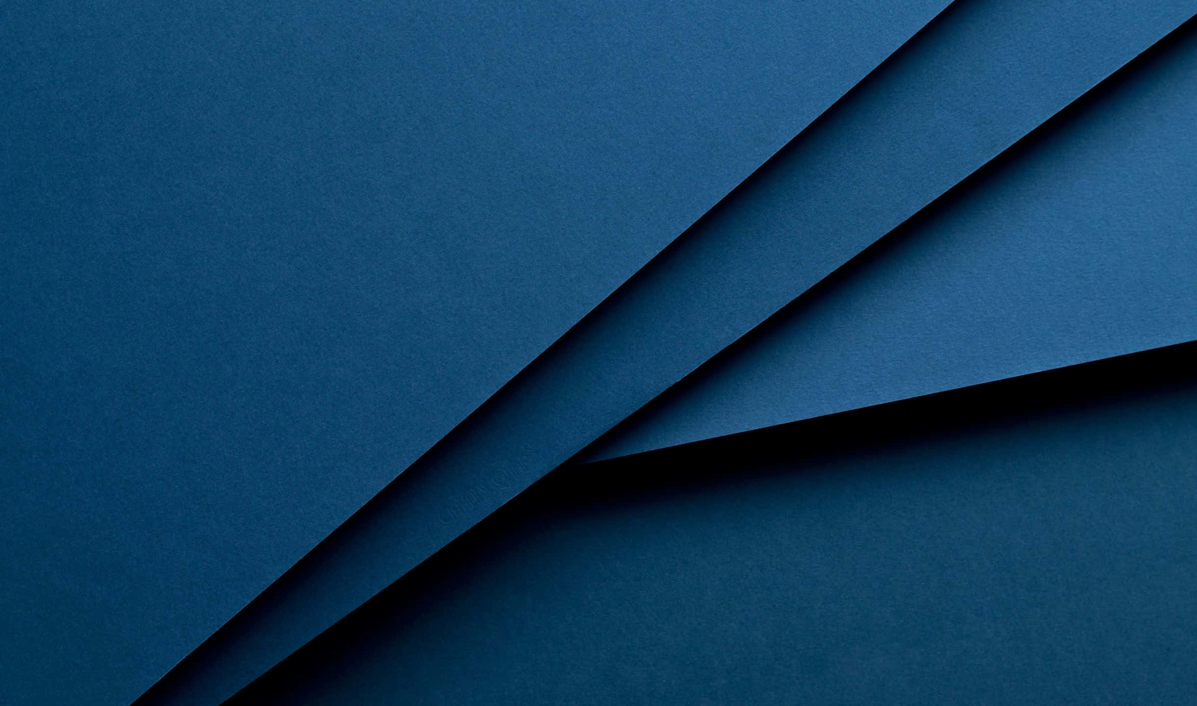 2440x1440 Material 桌布 壁紙 — 深藍色紋理紙張摺疊營造出極簡抽象構圖，帶有柔和陰影和乾淨線條。