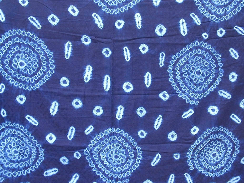 bandana 桌布 壁紙 — 深藍色紮染布料的特寫，帶有複雜的白色圓形和橢圓形圖案。