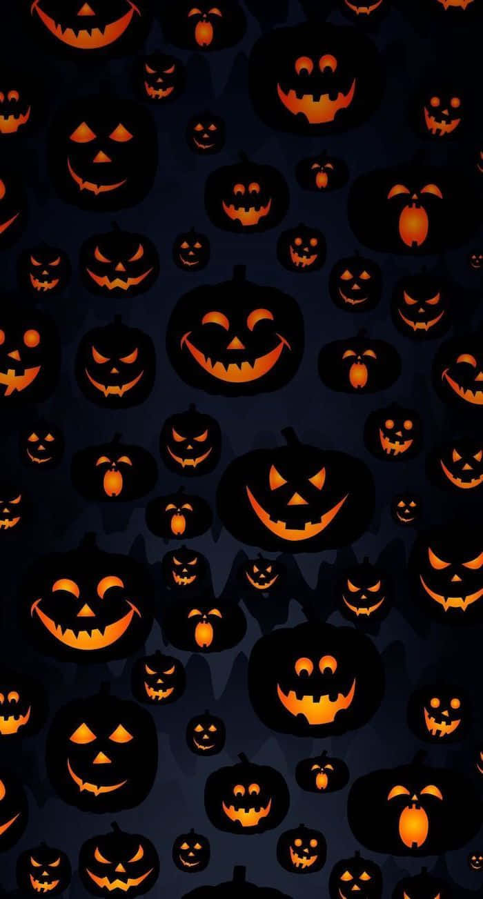 Orange Halloween 桌布 壁紙 — 深藍色背景上充滿了各種微笑表情的發光橙色南瓜燈。