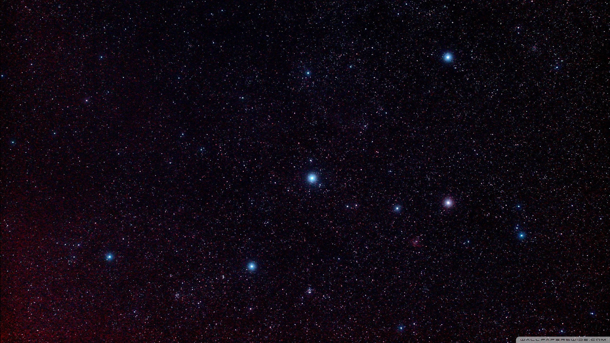 星星動圖 桌布 壁紙 — 深邃太空景觀，充滿無數星辰，左下角有明亮的紅色星雲發光。