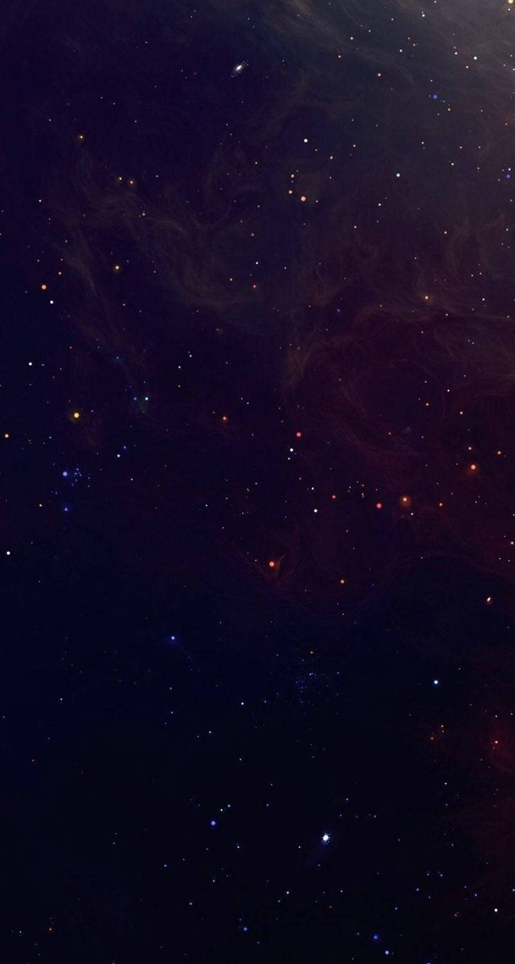 Dark Phone 桌布 壁紙 — 深邃太空景觀，充滿閃爍的星星和旋轉的宇宙塵埃雲，呈現豐富的紅色和藍色。