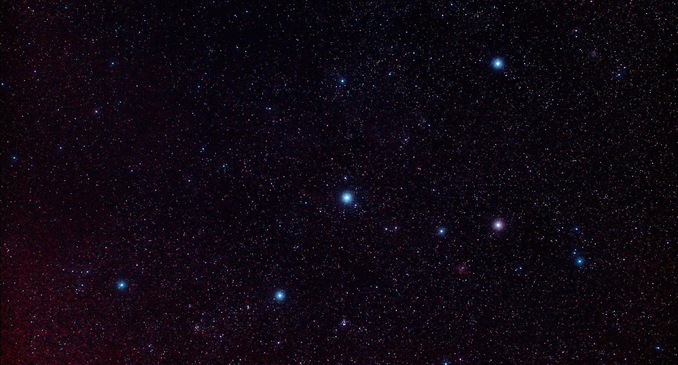 Stars 桌布 壁紙 — 深邃太空景觀，在黑暗的宇宙畫布上佈滿無數閃爍的星星，並帶有微妙的紅色星雲。