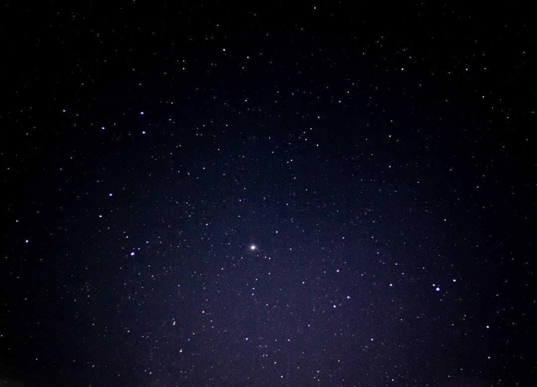 夜空 桌布 壁紙 — 深邃的夜空，充滿無數閃爍的星星和一個明亮的星體，在黑暗的廣闊中柔和地發光。