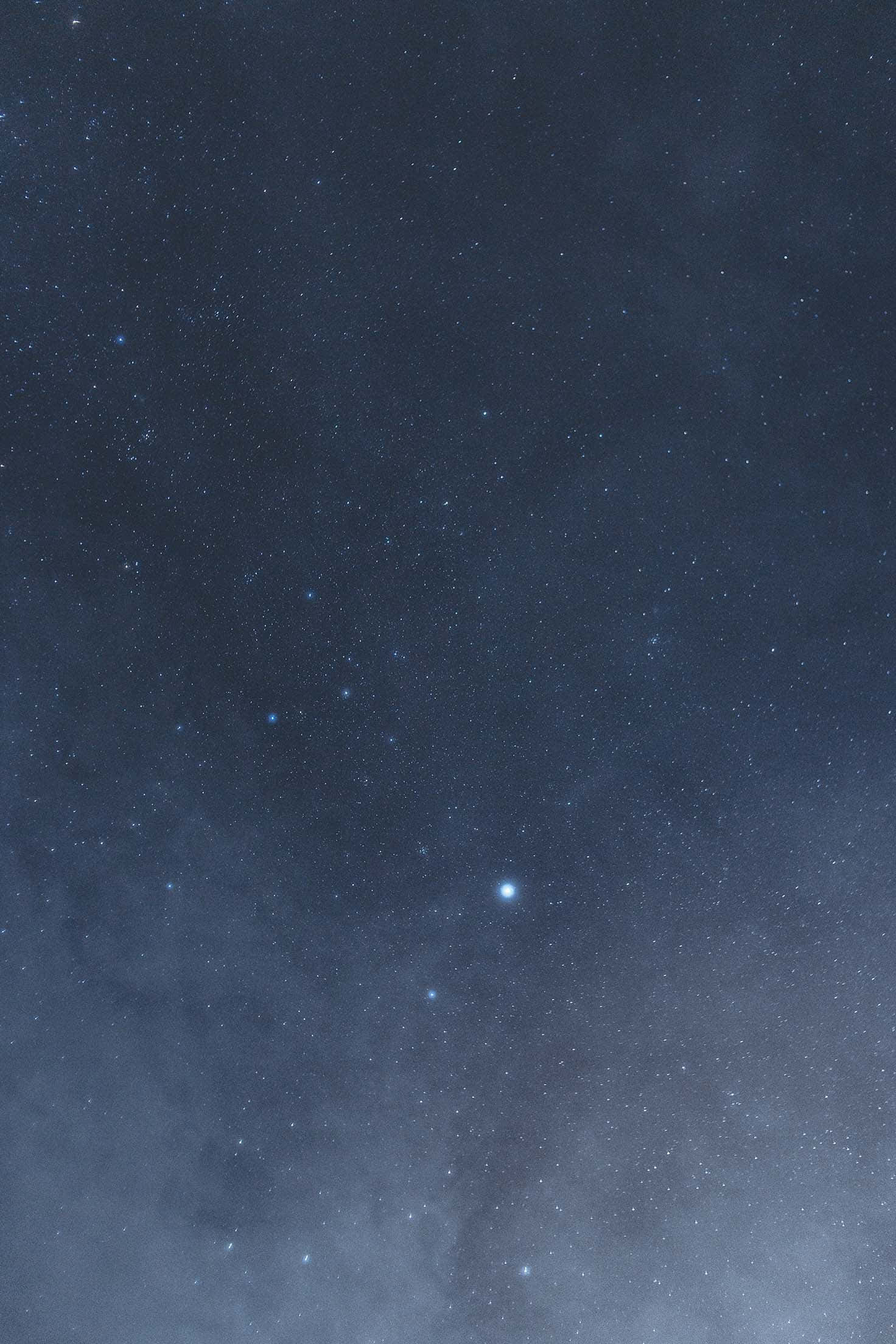 Best iPhone 桌布 壁紙 — 深邃的藍色夜空，充滿了無數閃爍的星星和微妙的宇宙塵埃雲。