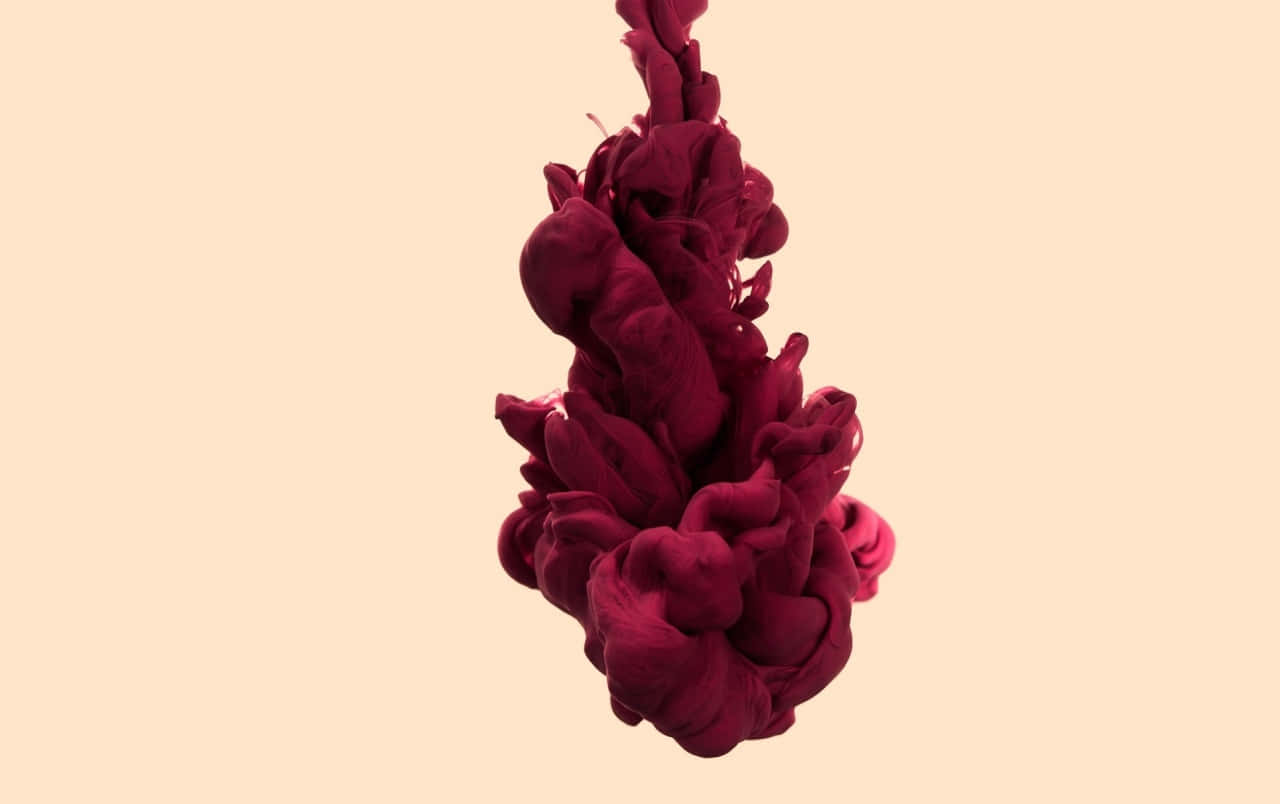 Red Smoke Effect 桌布 壁紙 — 深酒紅色墨水在柔和的桃色背景上戲劇性地旋轉，形成流暢的抽象動態。