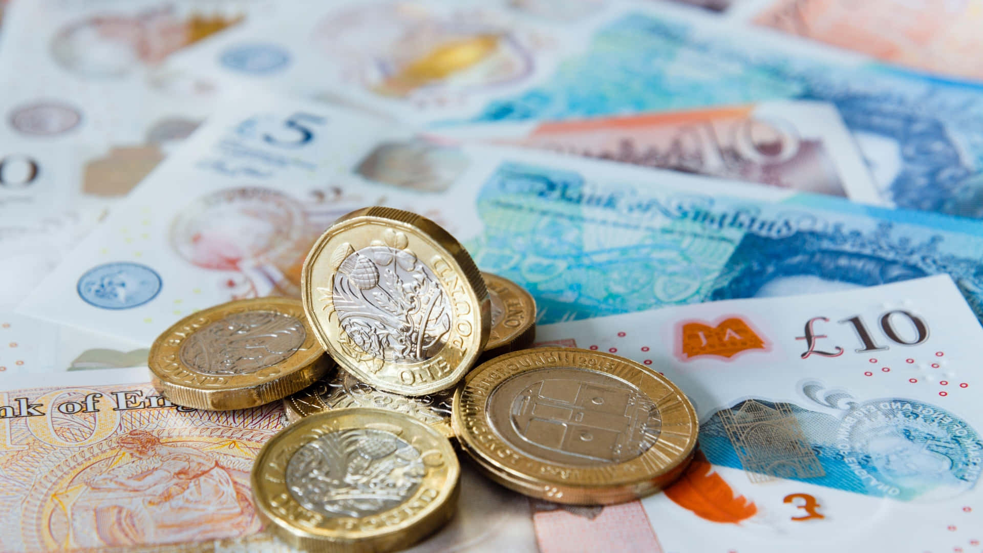 金錢 桌布 壁紙 — 淺景深下散落的英鎊硬幣和紙幣特寫。