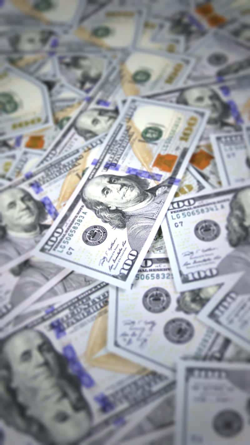 dollar 桌布 壁紙 — 淺景深拍攝散落的百元美鈔，焦點落在班傑明·富蘭克林的肖像上。