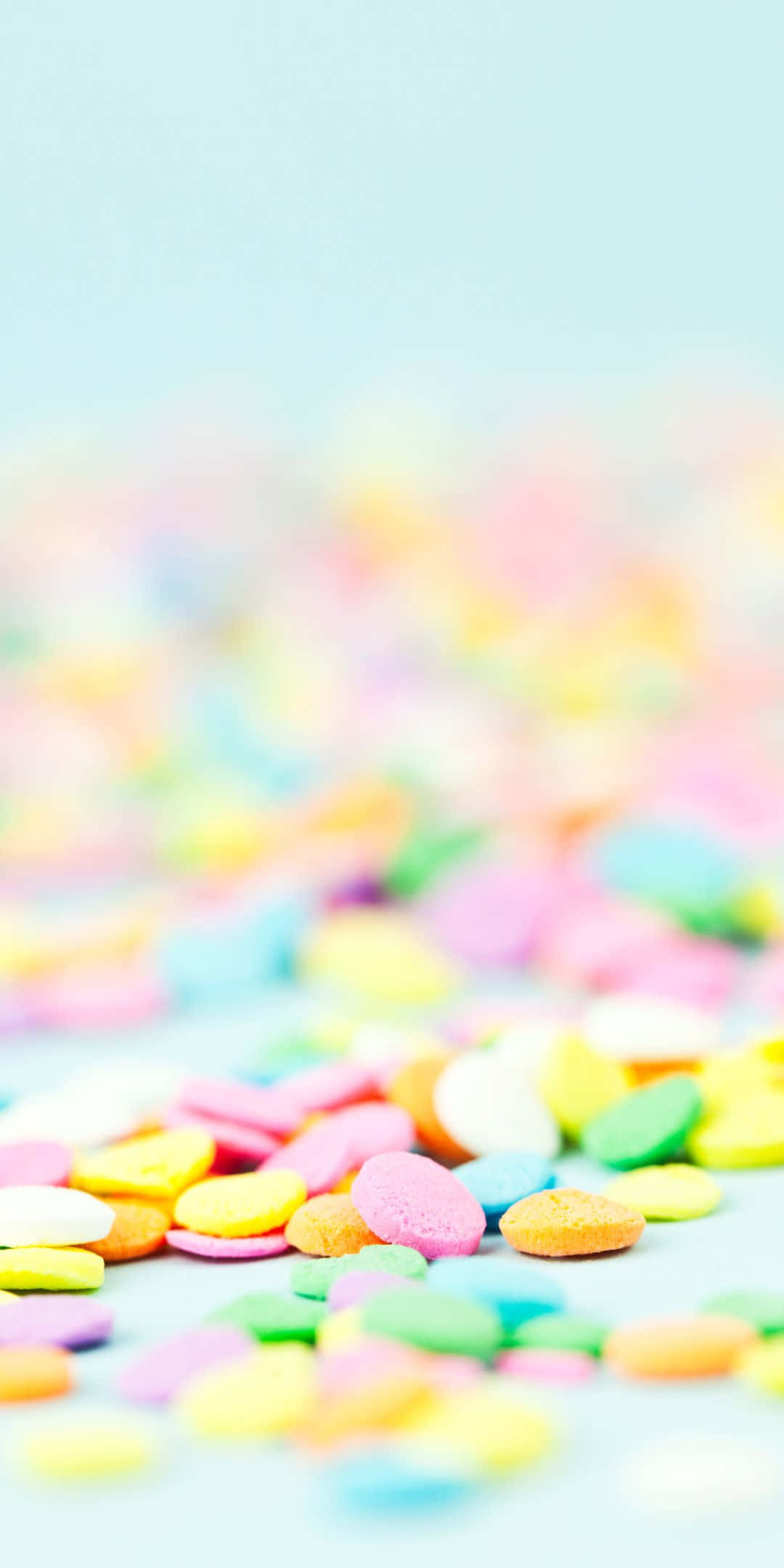 Sprinkles 桌布 壁紙 — 淺景深捕捉到柔軟藍色表面上散落的柔和色調糖果。
