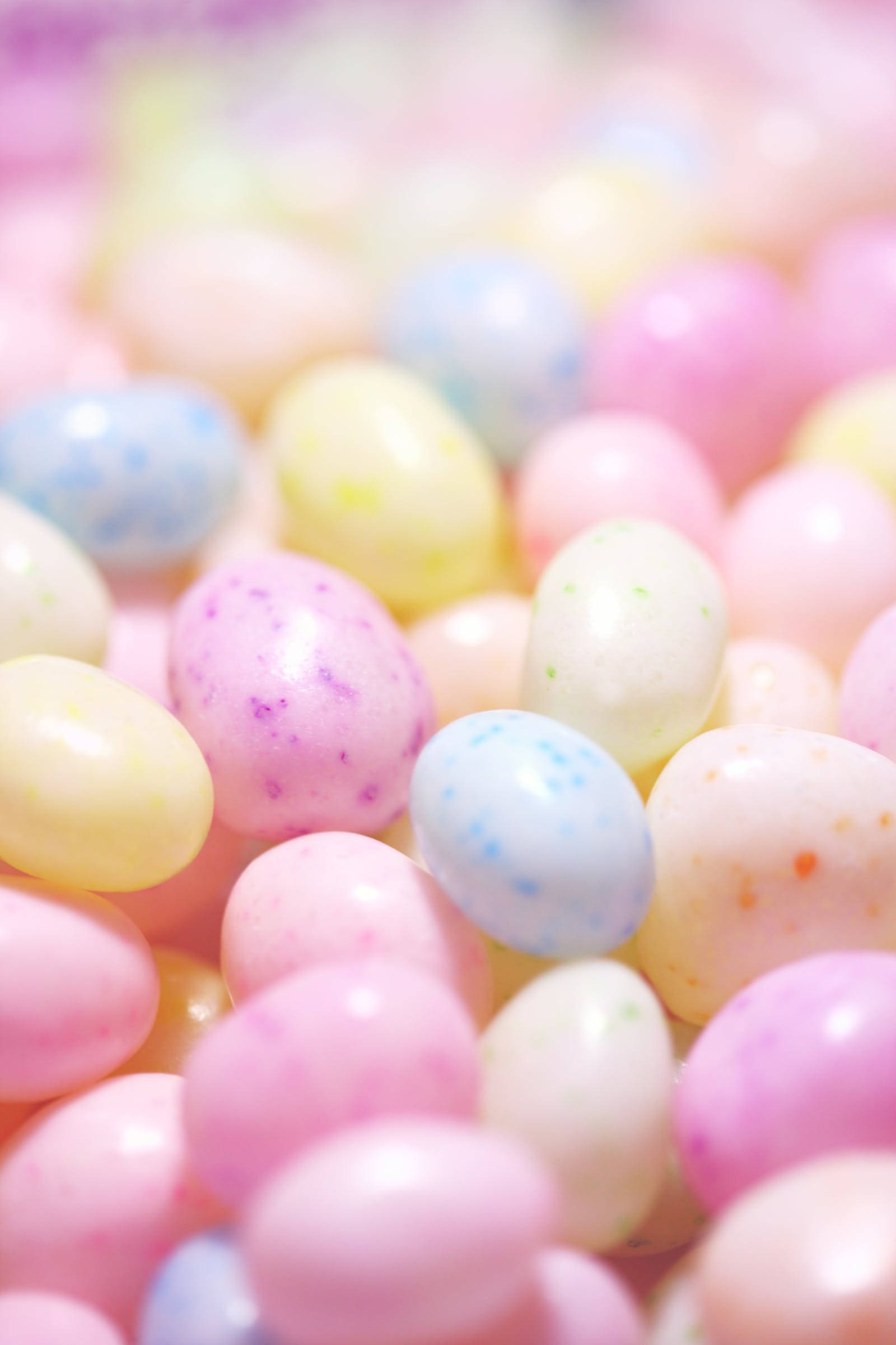 Pastel Pink Aesthetic 桌布 壁紙 — 淺景深特寫，拍攝粉彩色斑點軟糖豆，背景柔和散景。