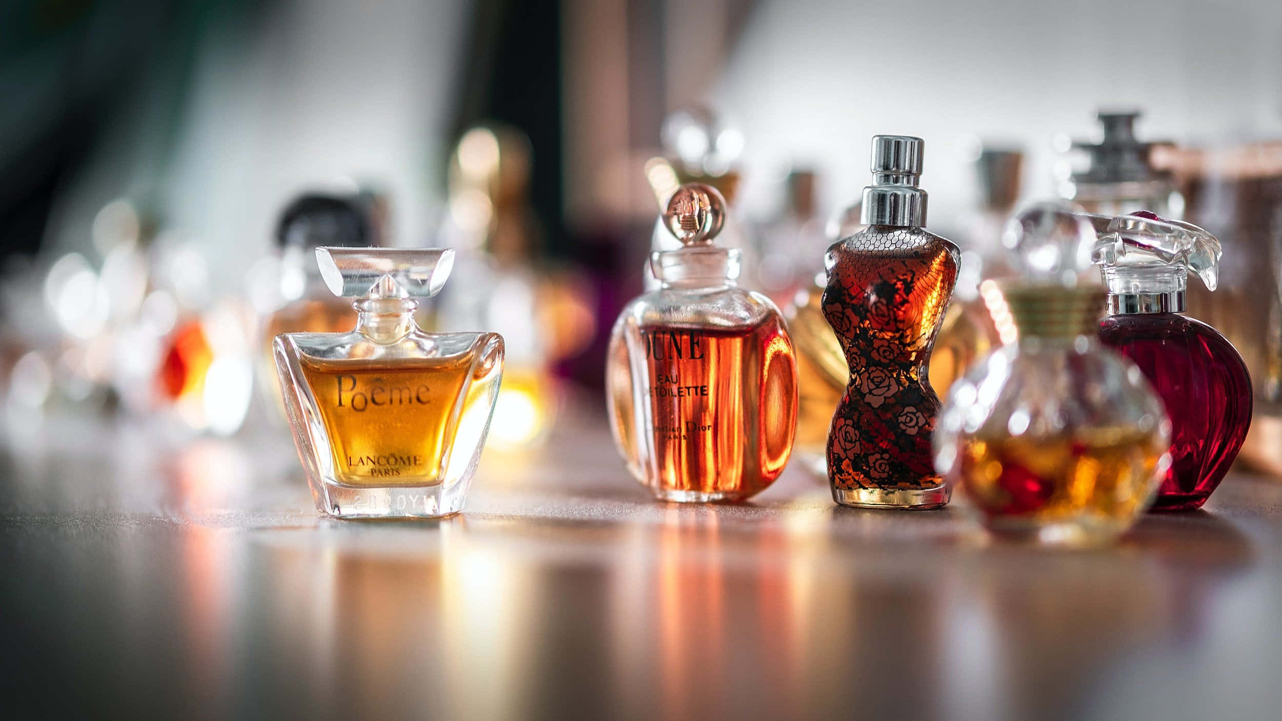 Spring Perfume 桌布 壁紙 — 淺景深突顯了反射表面上帶有琥珀色液體的優雅香水瓶。