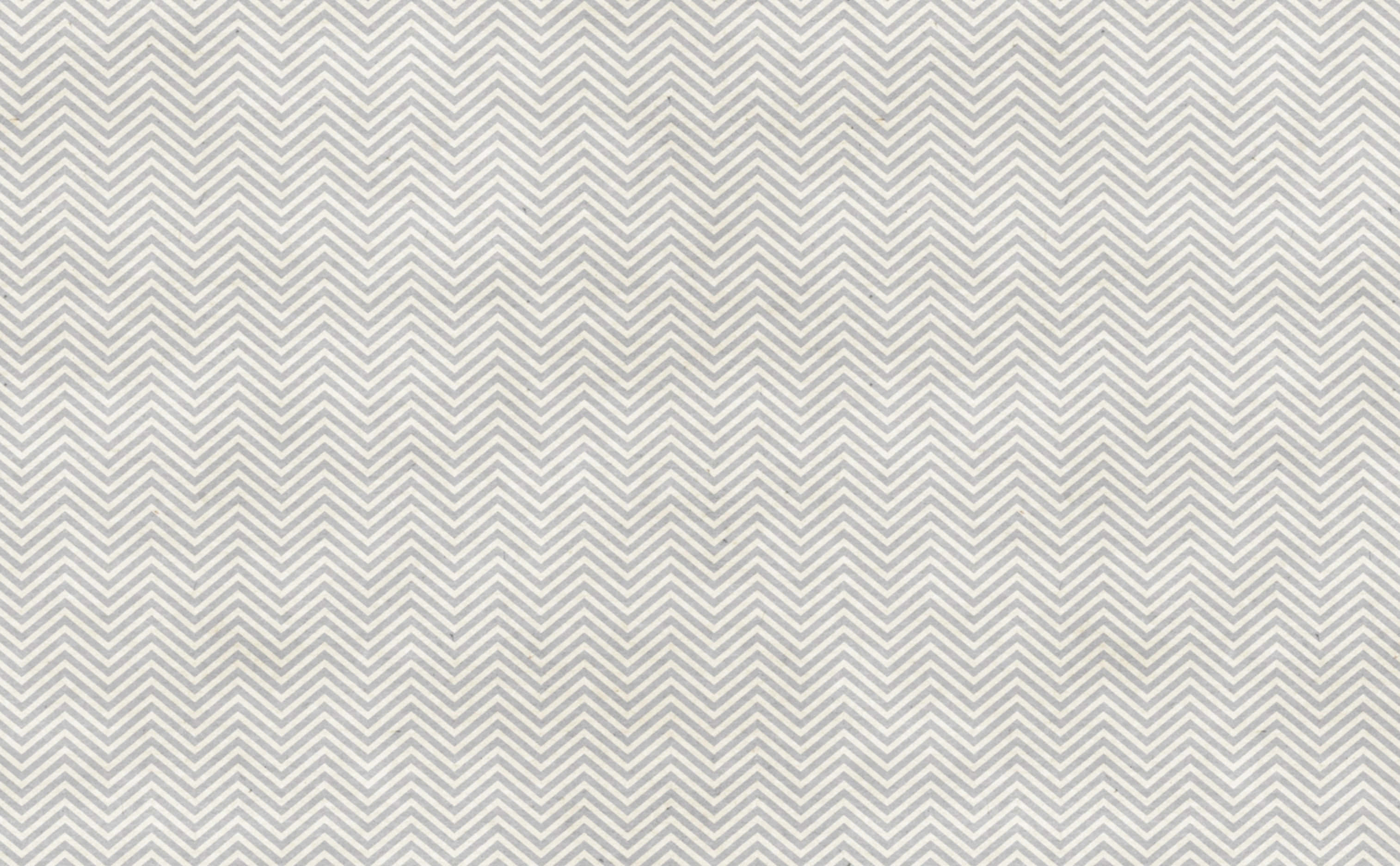 Cute Chevron 桌布 壁紙 — 淺灰色和白色人字紋圖案壁紙的特寫，帶有細微紋理。