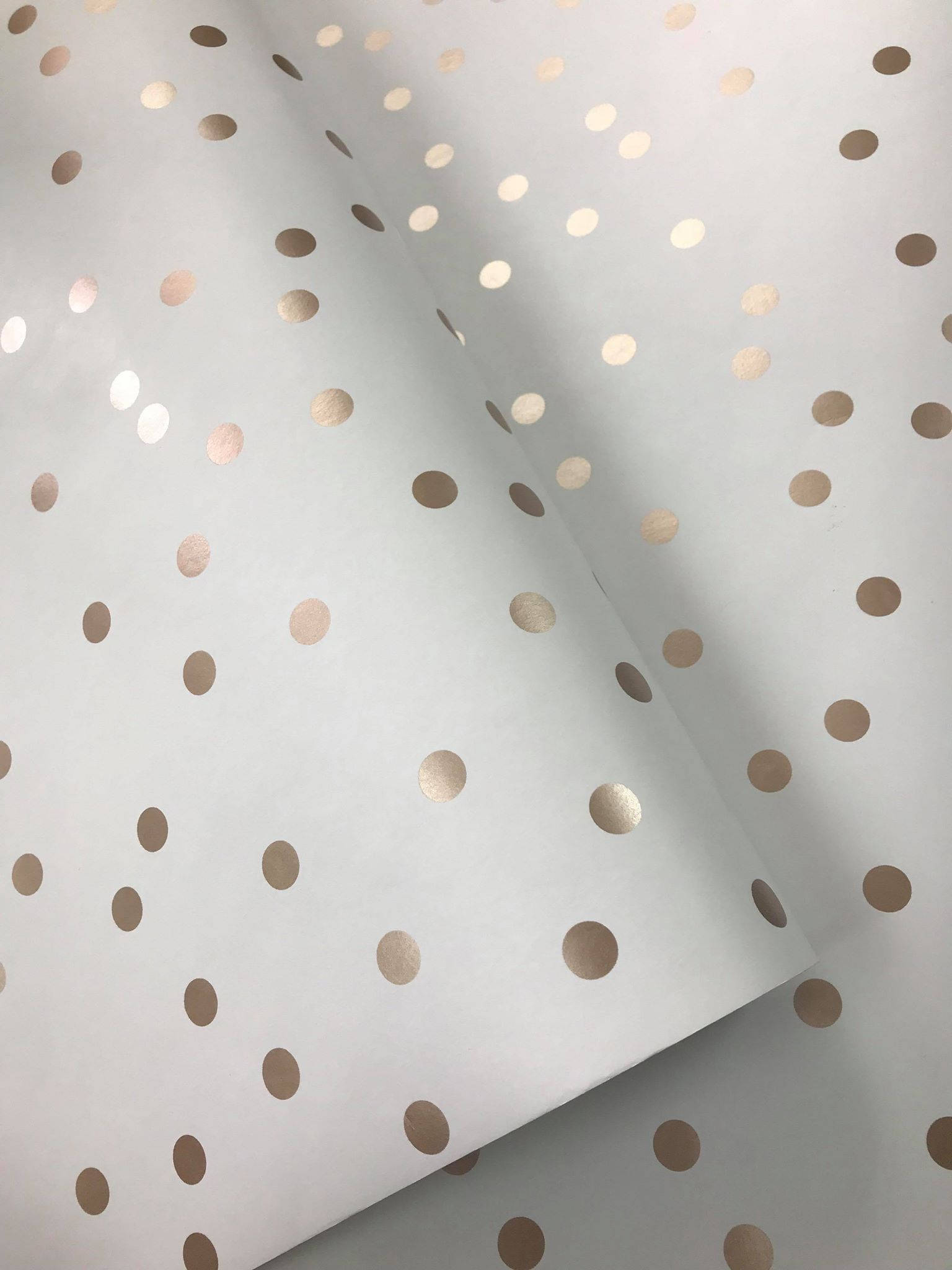 Dot 桌布 壁紙 — 淺灰色壁紙的特寫，帶有散落的玫瑰金箔圓點和柔軟的摺痕。