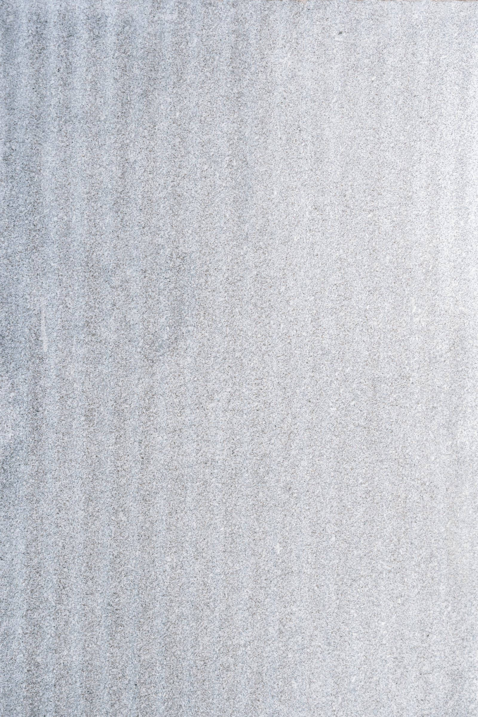 Plain Grey 桌布 壁紙 — 淺灰色紋理混凝土表面的特寫，帶有微妙的垂直條紋和斑點狀紋理。