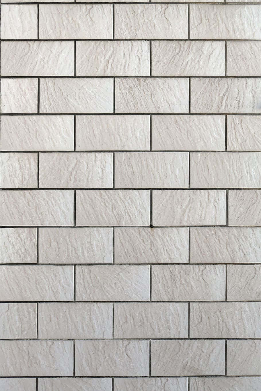 Tiles 桌布 壁紙 — 淺灰色紋理石磚的特寫，以整齊的水平磚塊圖案排列，帶有深色填縫線。