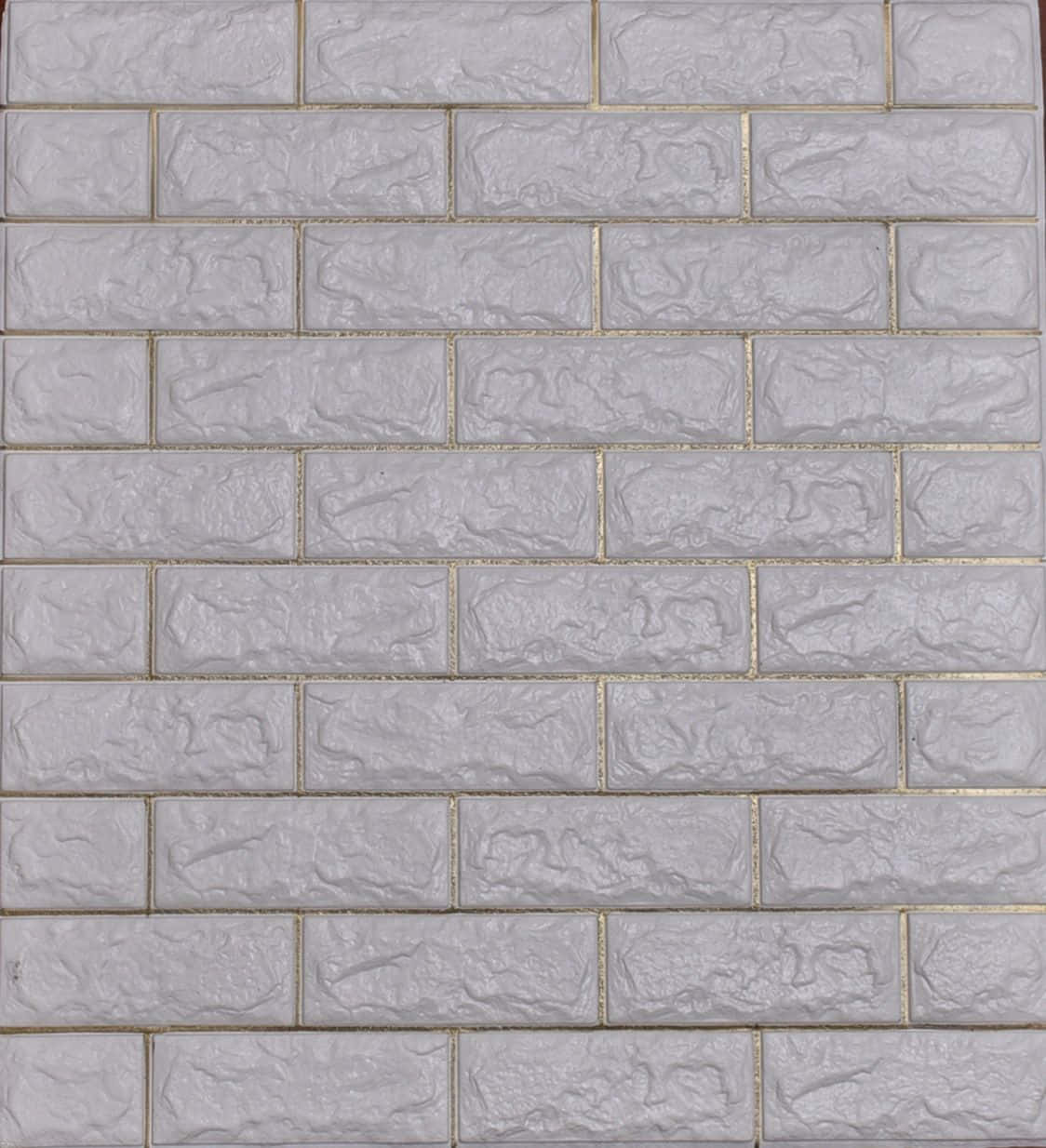 wall 桌布 壁紙 — 淺灰色紋理磚塊的近距離特寫，金色填縫線以跑砌圖案排列。