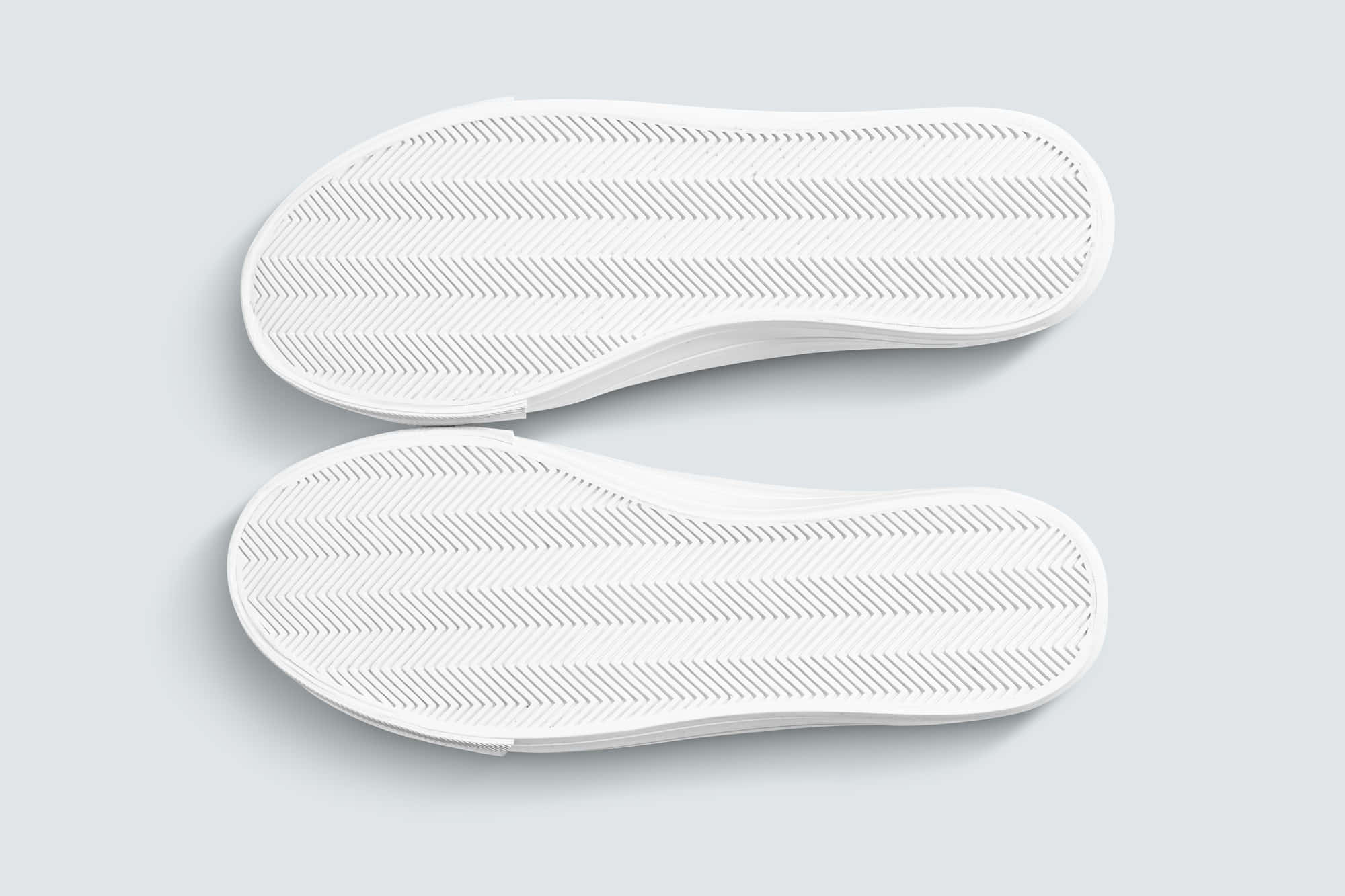 鞋子 桌布 壁紙 — 淺灰色背景上兩個白色 slip-on 鞋底的人字形花紋俯視圖。