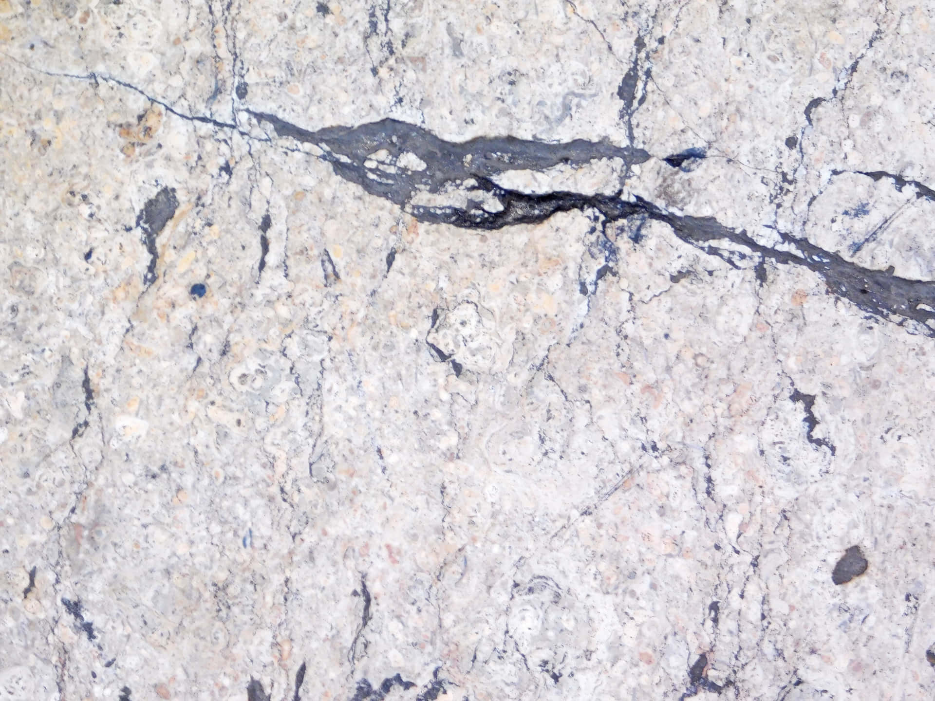 Marble Texture 壁紙 — 淺灰色花崗岩表面的特寫，帶有深色紋理和細微的土色斑點。
