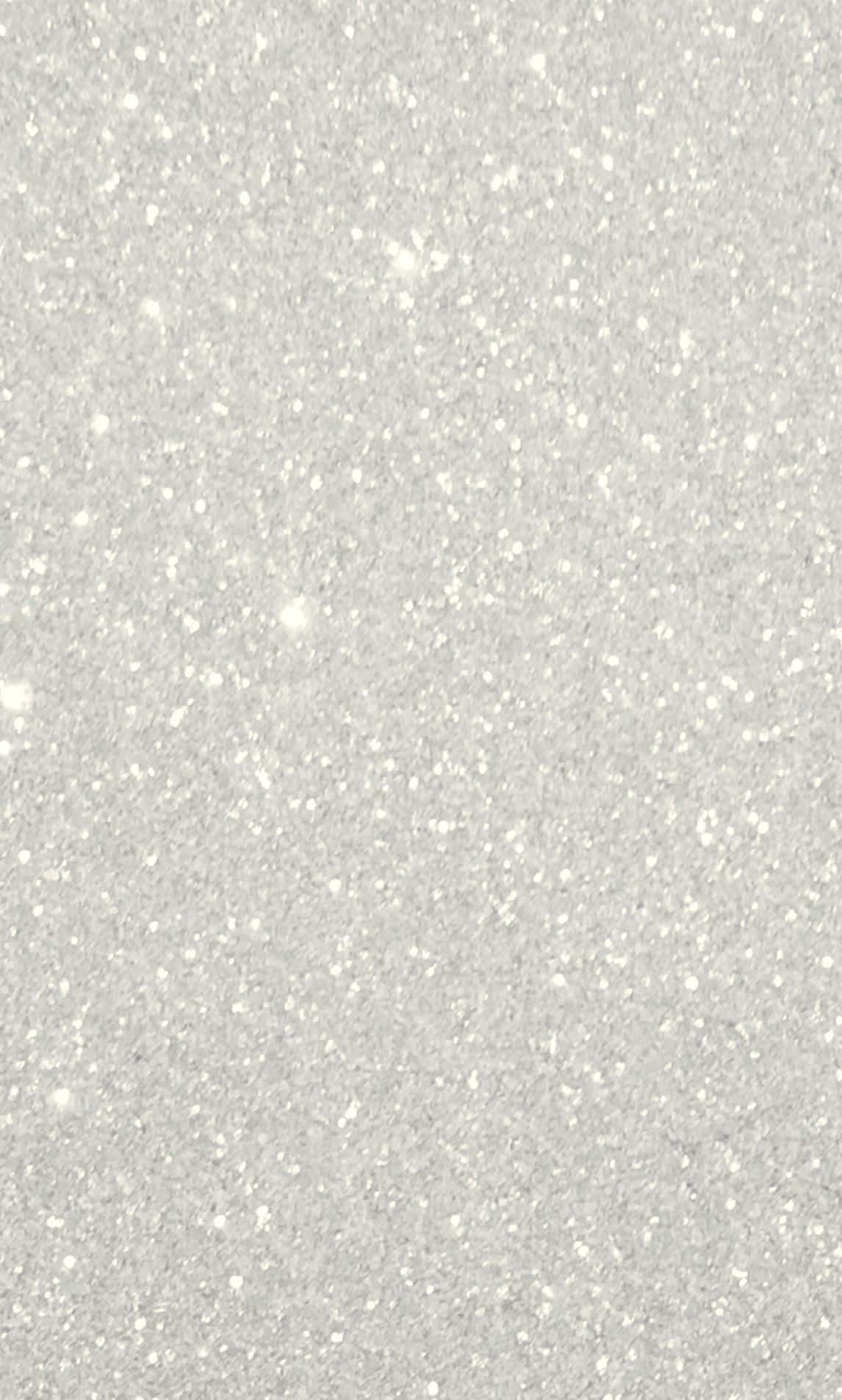 White Glitter 桌布 壁紙 — 淺灰色表面的特寫，表面散佈著細小的白色亮粉顆粒，捕捉柔和光線。