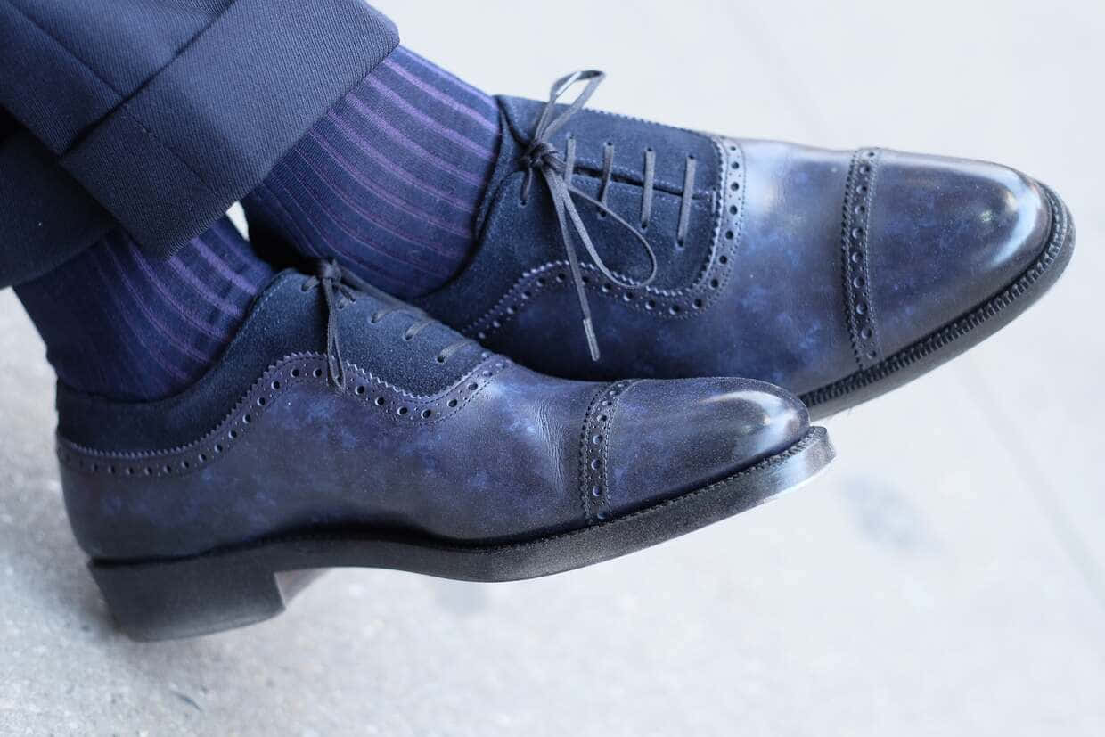 Navy Blue Shoes 桌布 壁紙 — 淺灰色路面上，擦亮的深藍色布洛克鞋配條紋襪子和西裝褲的特寫。
