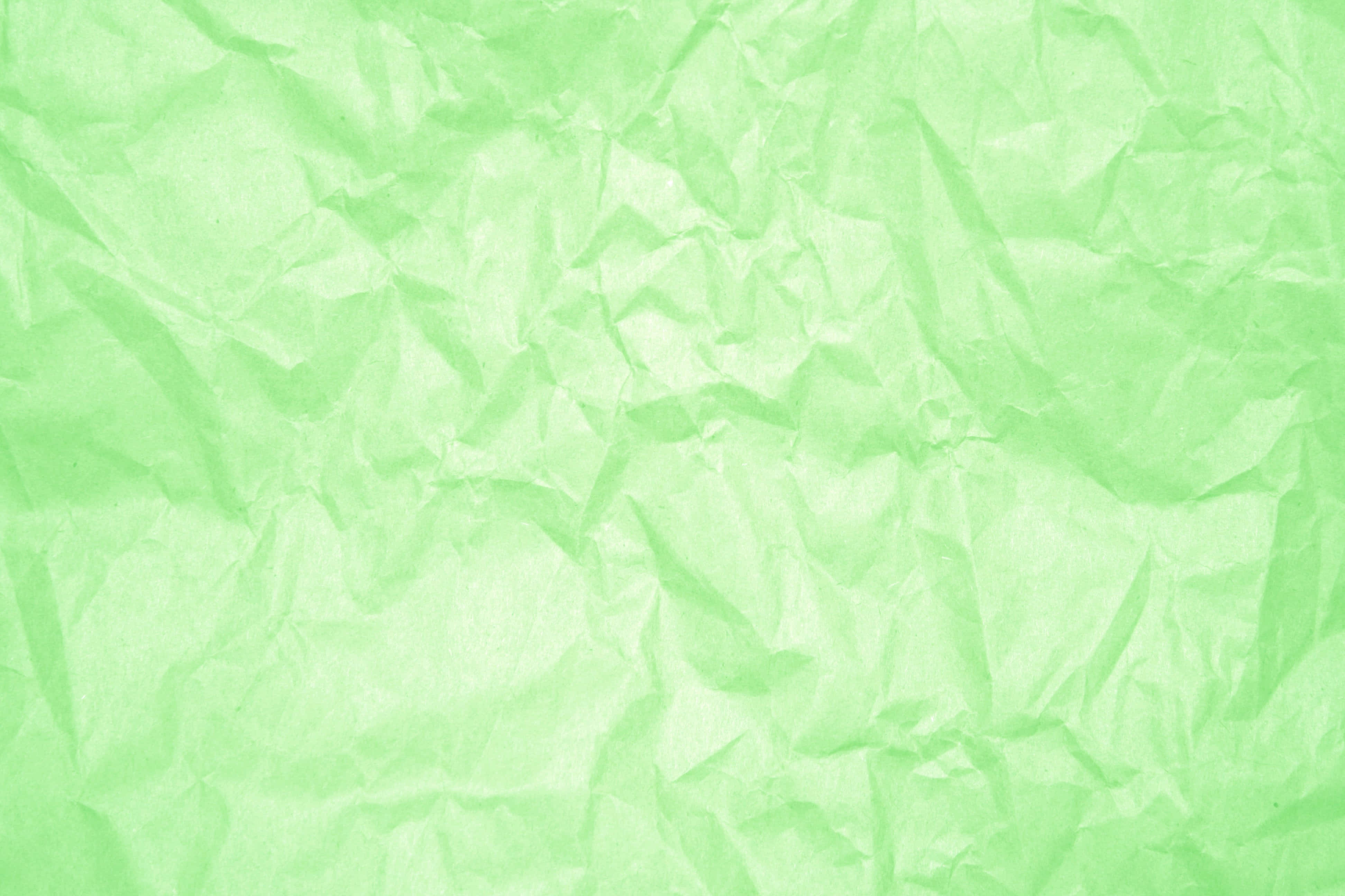 Light Green 桌布 壁紙 — 淺綠色皺紙的特寫，帶有柔軟的摺痕和陰影，營造出紋理表面。