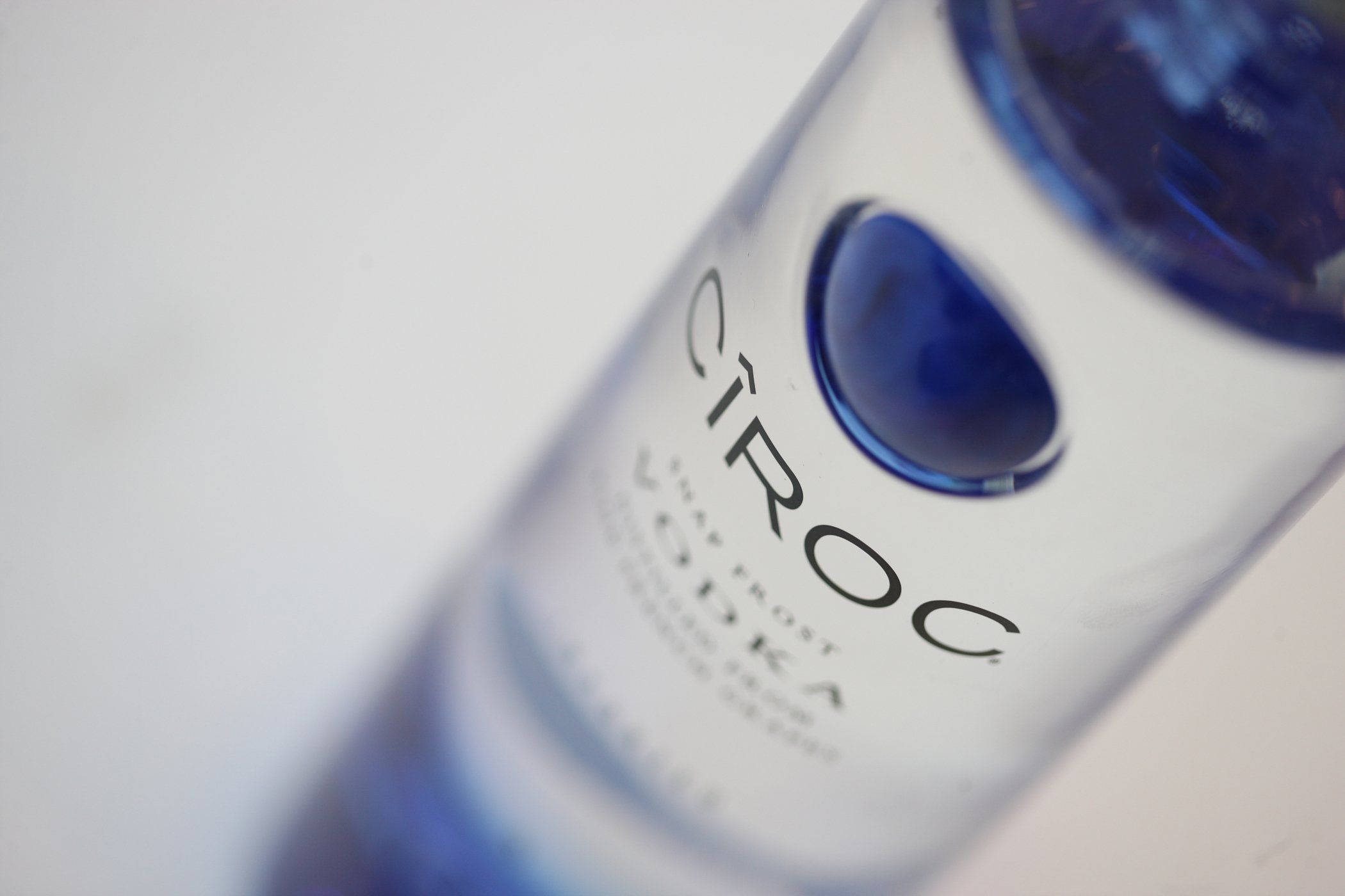 Drink 桌布 壁紙 — 清晰Cîroc伏特加酒瓶的特寫，帶有藍色點綴和模糊背景。