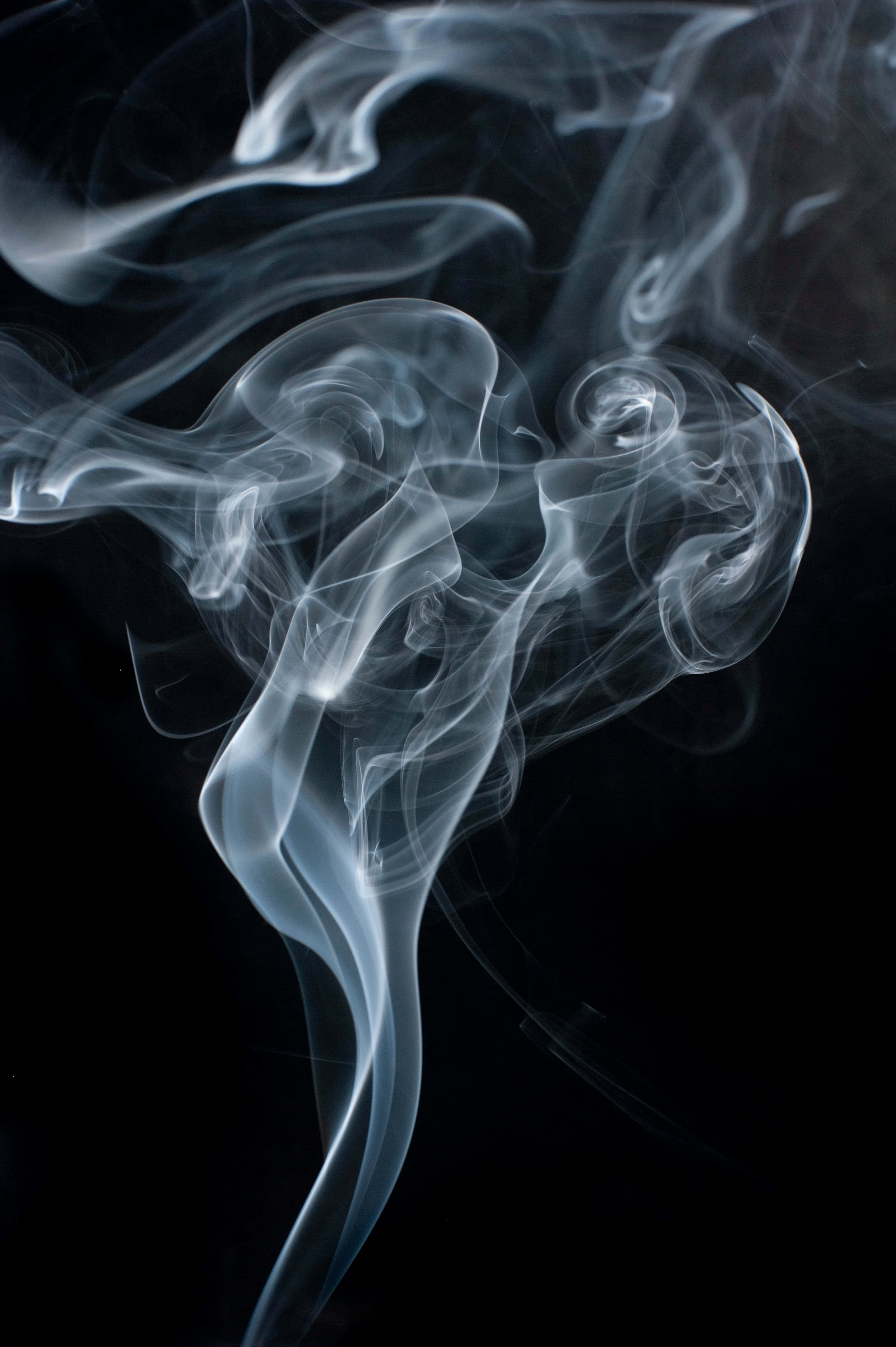 Smoke Trail 桌布 壁紙 — 清涼藍煙的縹緲縷縷在深邃的黑色虛空中優雅地旋轉，創造出光與影的迷人抽象舞蹈。