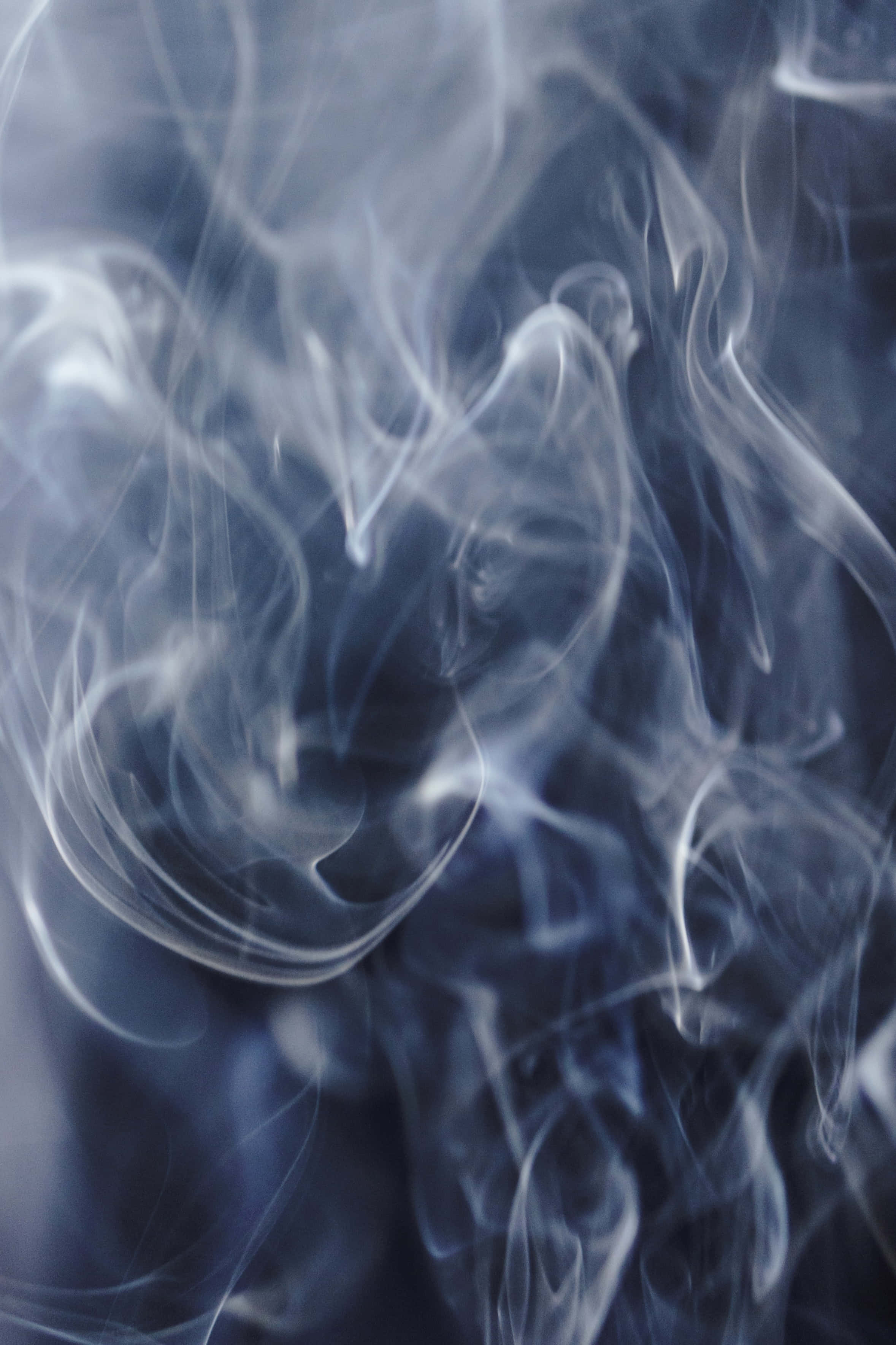 Smoke Trail 桌布 壁紙 — 清涼藍煙的縹緲縷縷在黑暗背景下旋轉扭動，上演一場迷人的抽象舞蹈。