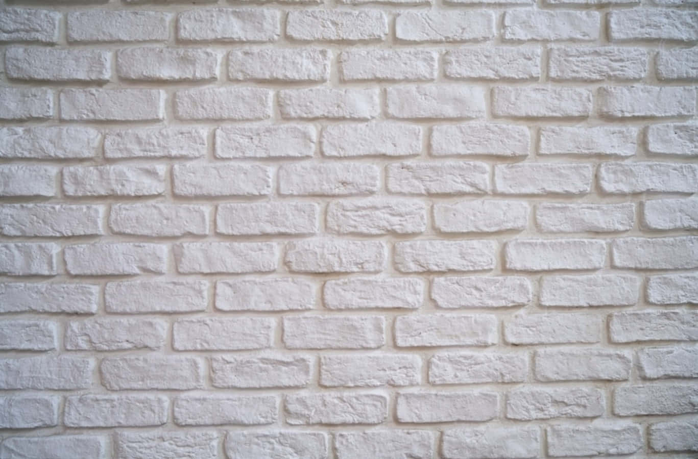 Brick 桌布 壁紙 — 清潔白色磚牆的特寫，帶有紋理灰泥線條和柔和自然光線。