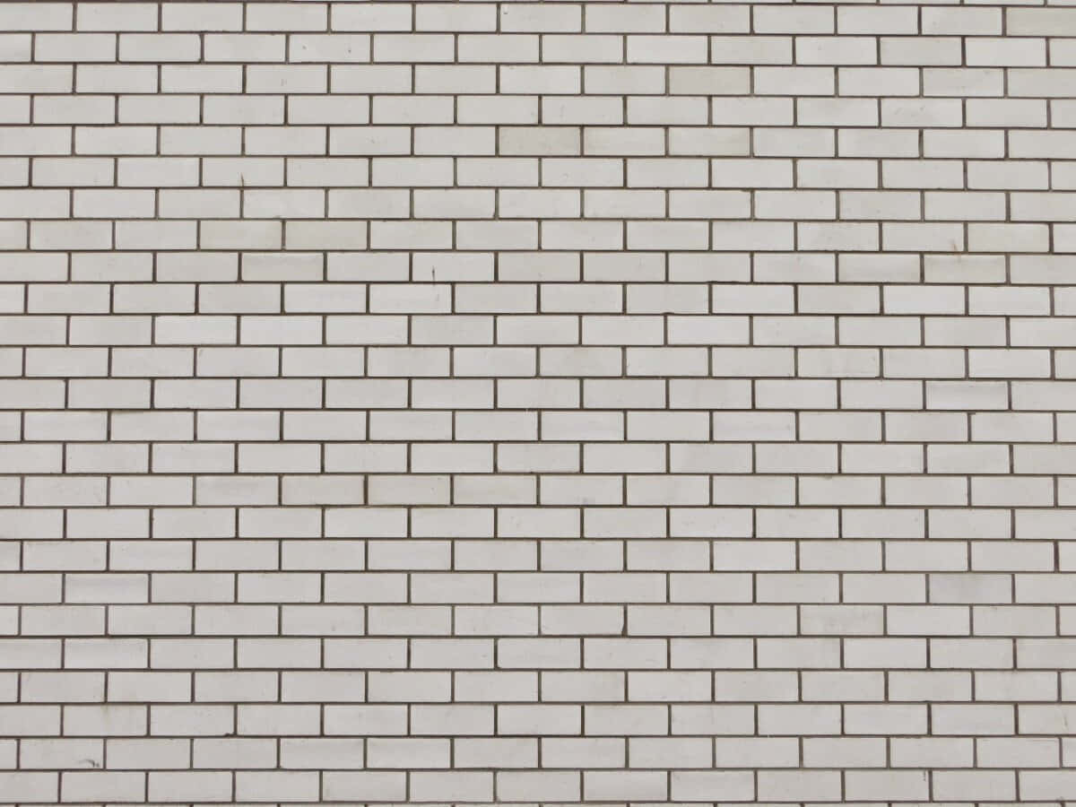 Brick Wall 桌布 壁紙 — 清潔白色磚牆的特寫，帶有細微的灰色砂漿線條和微弱的表面瑕疵。