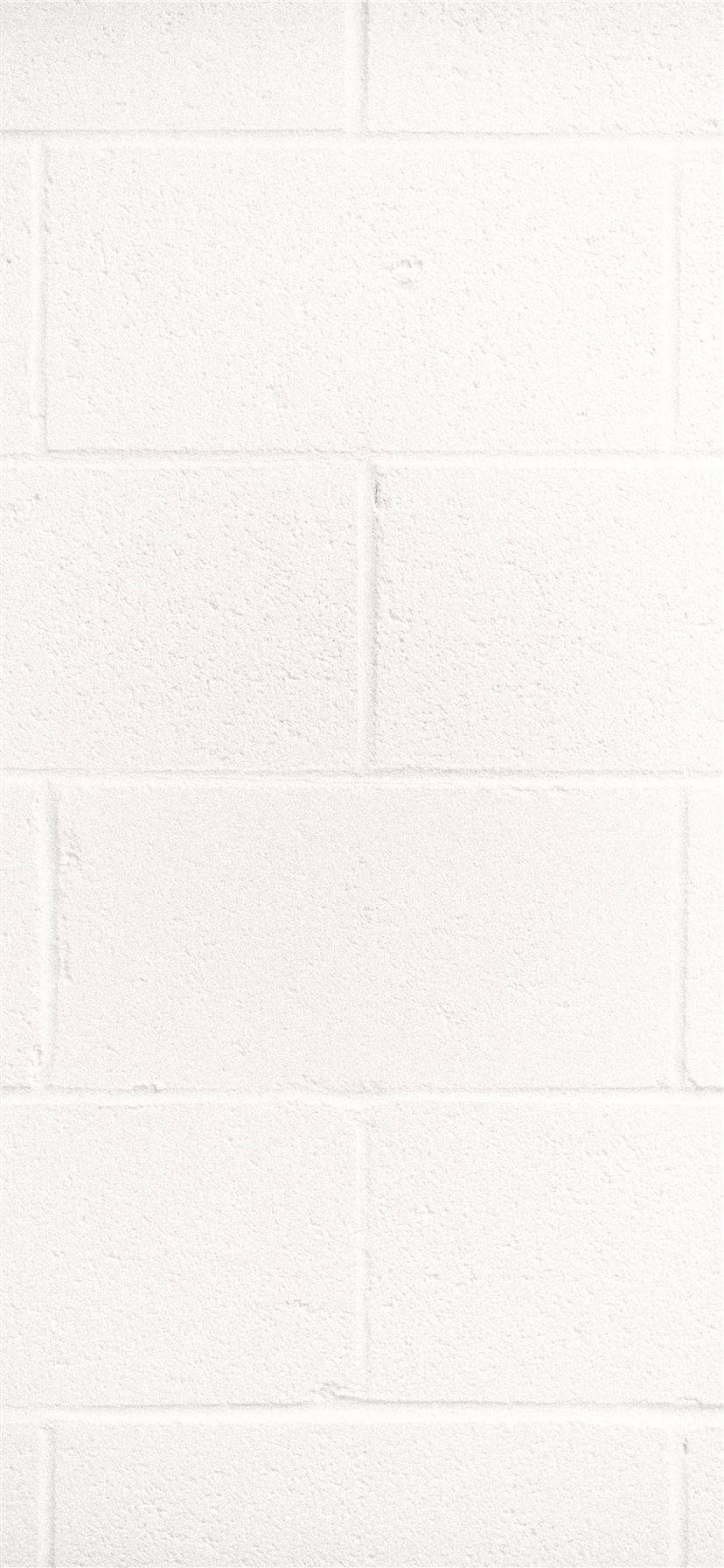White iPhone 桌布 壁紙 — 清潔白色磚牆的特寫，帶有細微紋理和砂漿線。
