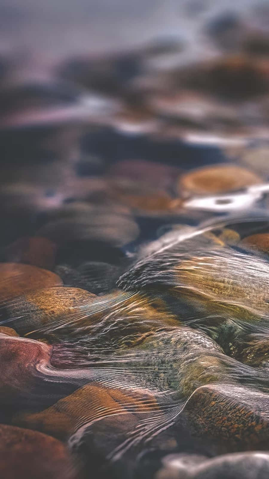 Relaxing 桌布 壁紙 — 清澈的水在淺溪中輕輕泛起漣漪，流過光滑圓潤的石頭，帶有柔和的大地色調。