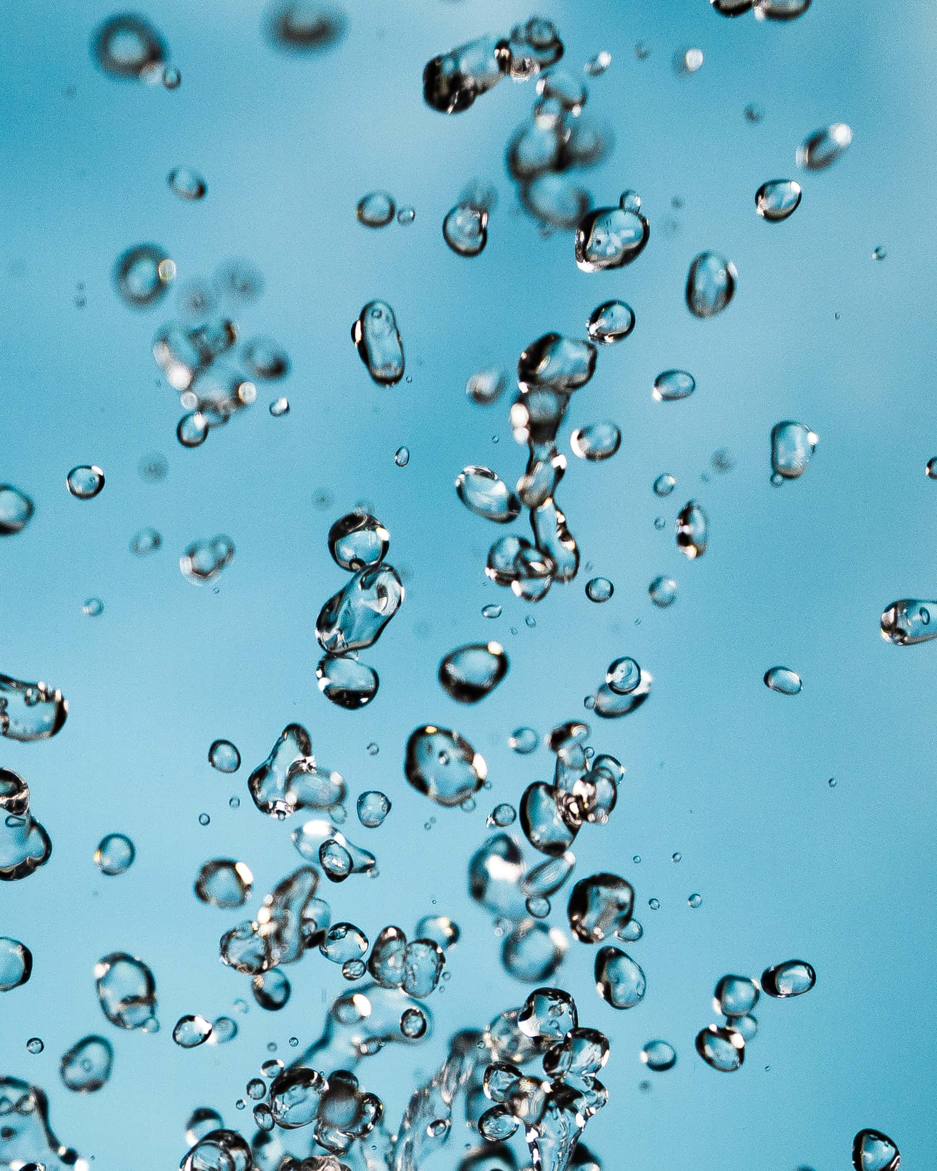Bubble 桌布 壁紙 — 清澈的水滴懸浮在半空中，背景為柔和的藍色漸變。