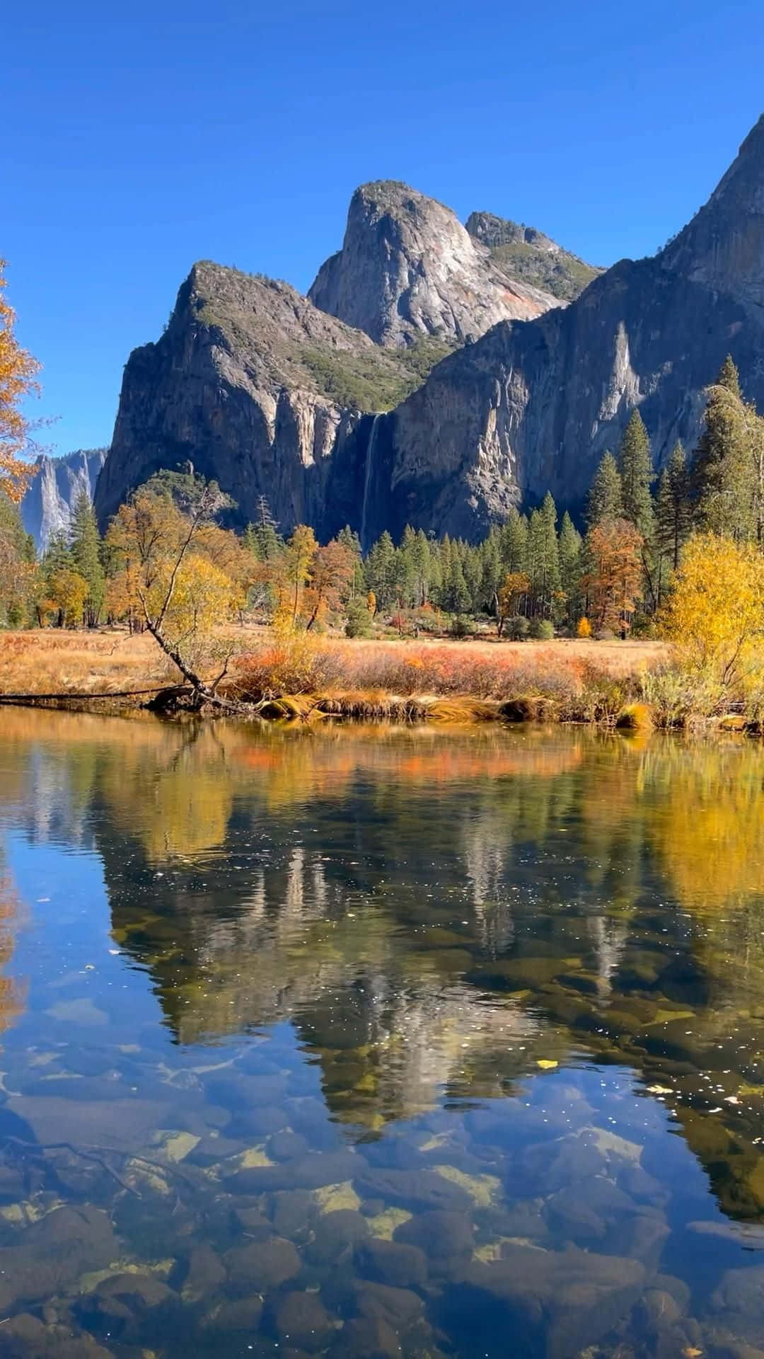 Beautiful Nature 桌布 壁紙 — 清澈的河流映照著高聳的花崗岩懸崖和秋樹，天空湛藍。