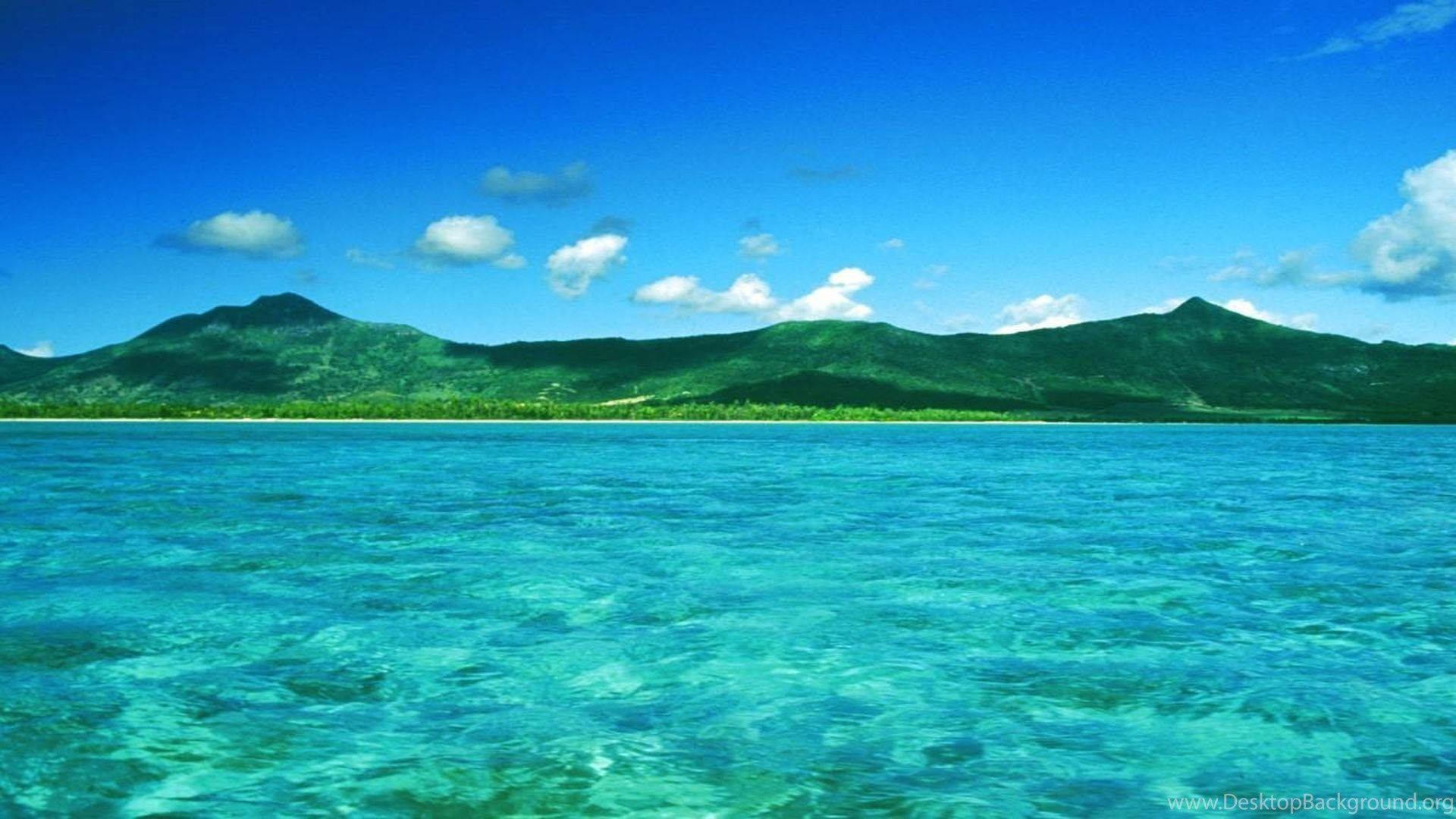 Mauritius 桌布 壁紙 — 清澈的碧綠海水延伸至鬱鬱蔥蔥的青山，天空湛藍，白雲點綴。