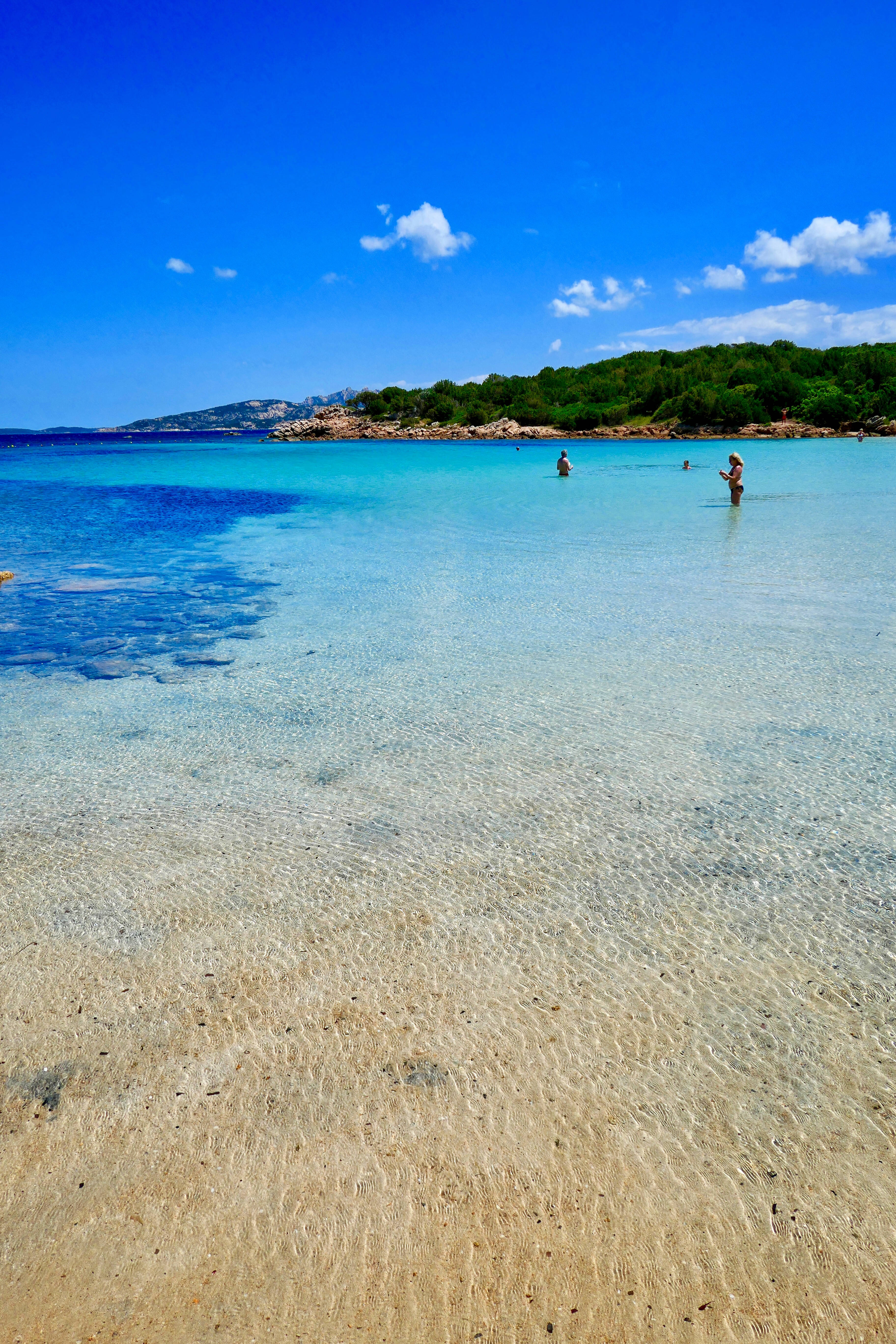 Palau 桌布 壁紙 — 清澈的碧綠海水拍打著沙灘，天空湛藍，白雲點點。