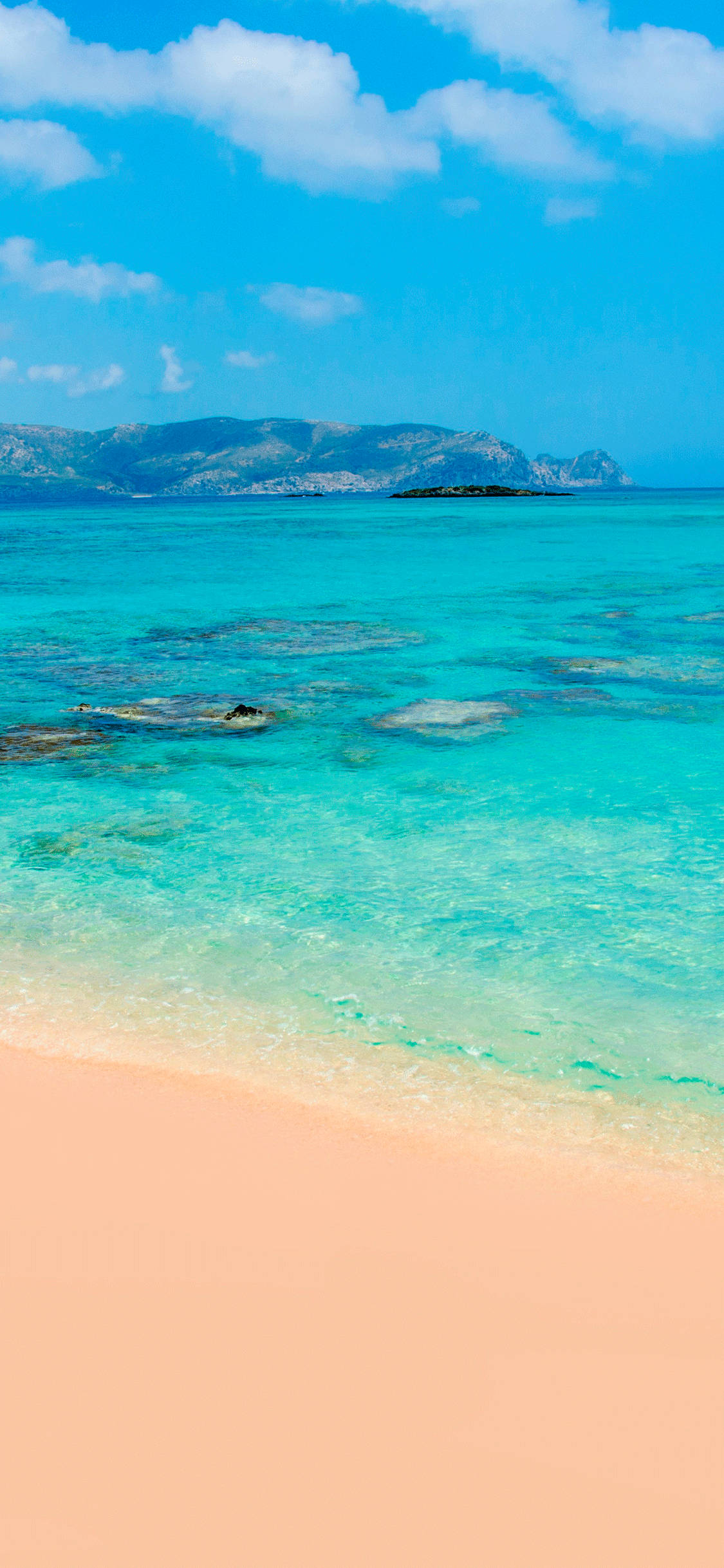 iPhone X Beach 桌布 壁紙 — 清澈碧綠的海水輕輕拍打著柔軟的蜜桃色沙灘，上方是藍天白雲。