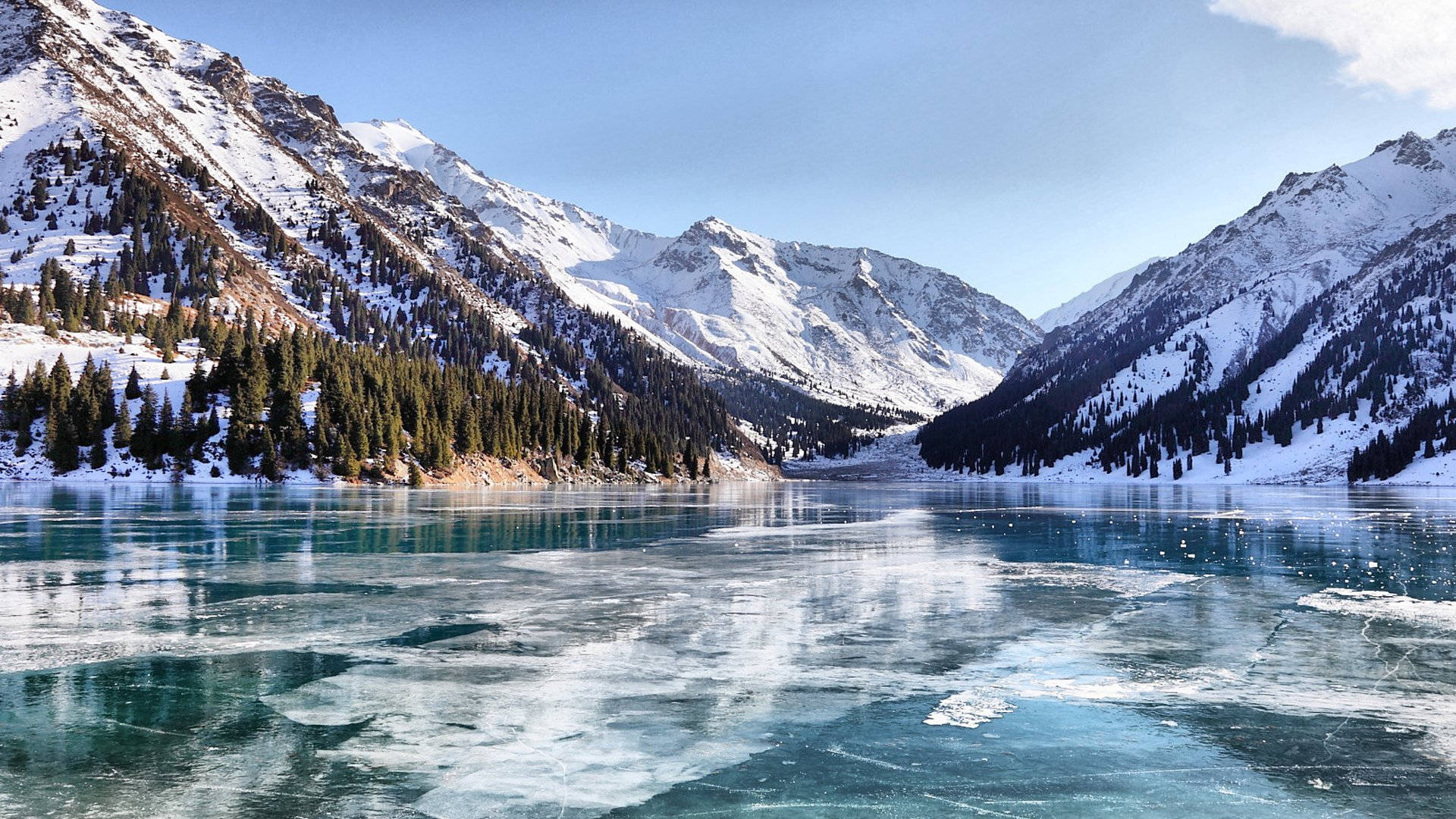 Lake 桌布 壁紙 — 清澈藍天下，白雪覆蓋的山巒之間，一個冰封的綠松石色湖泊。
