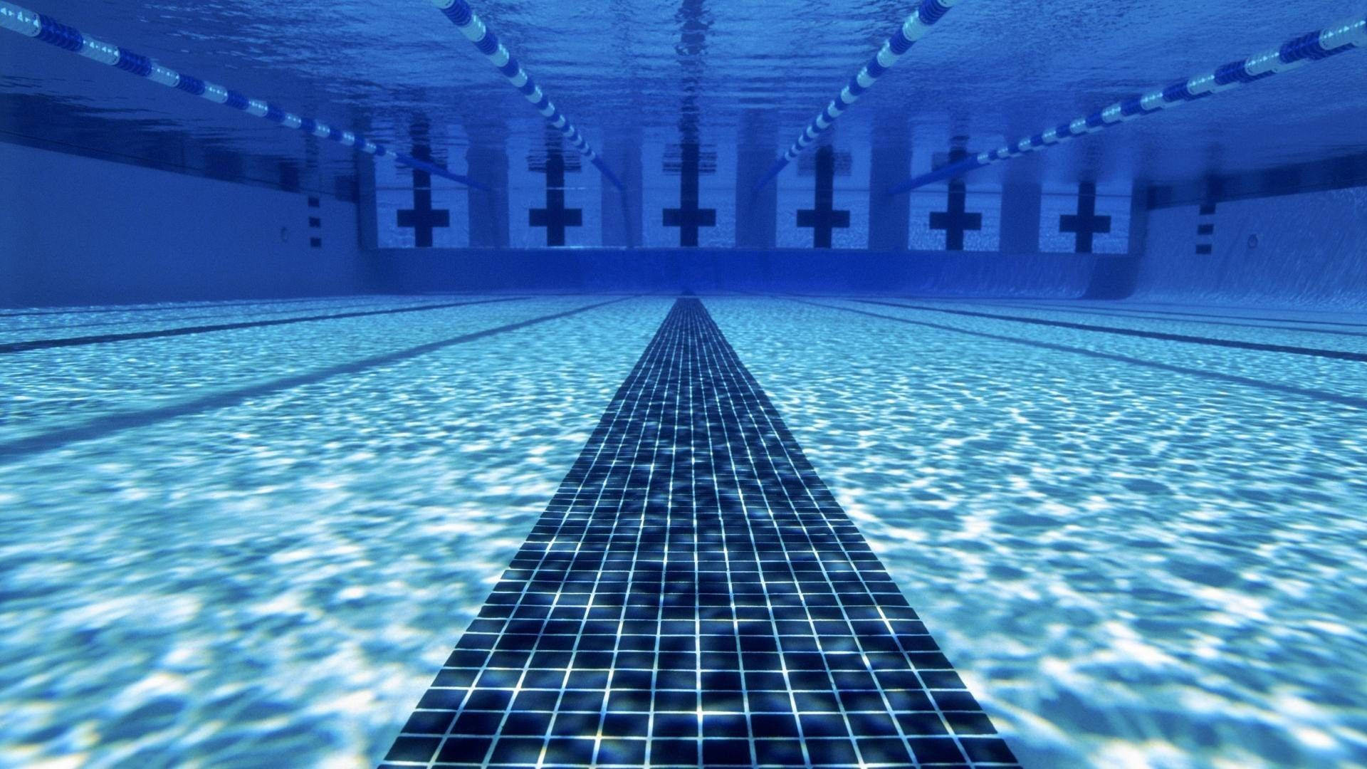 Swimming 桌布 壁紙 — 游泳池的水底視圖，藍色瓷磚和泳道分隔線延伸至遠方。