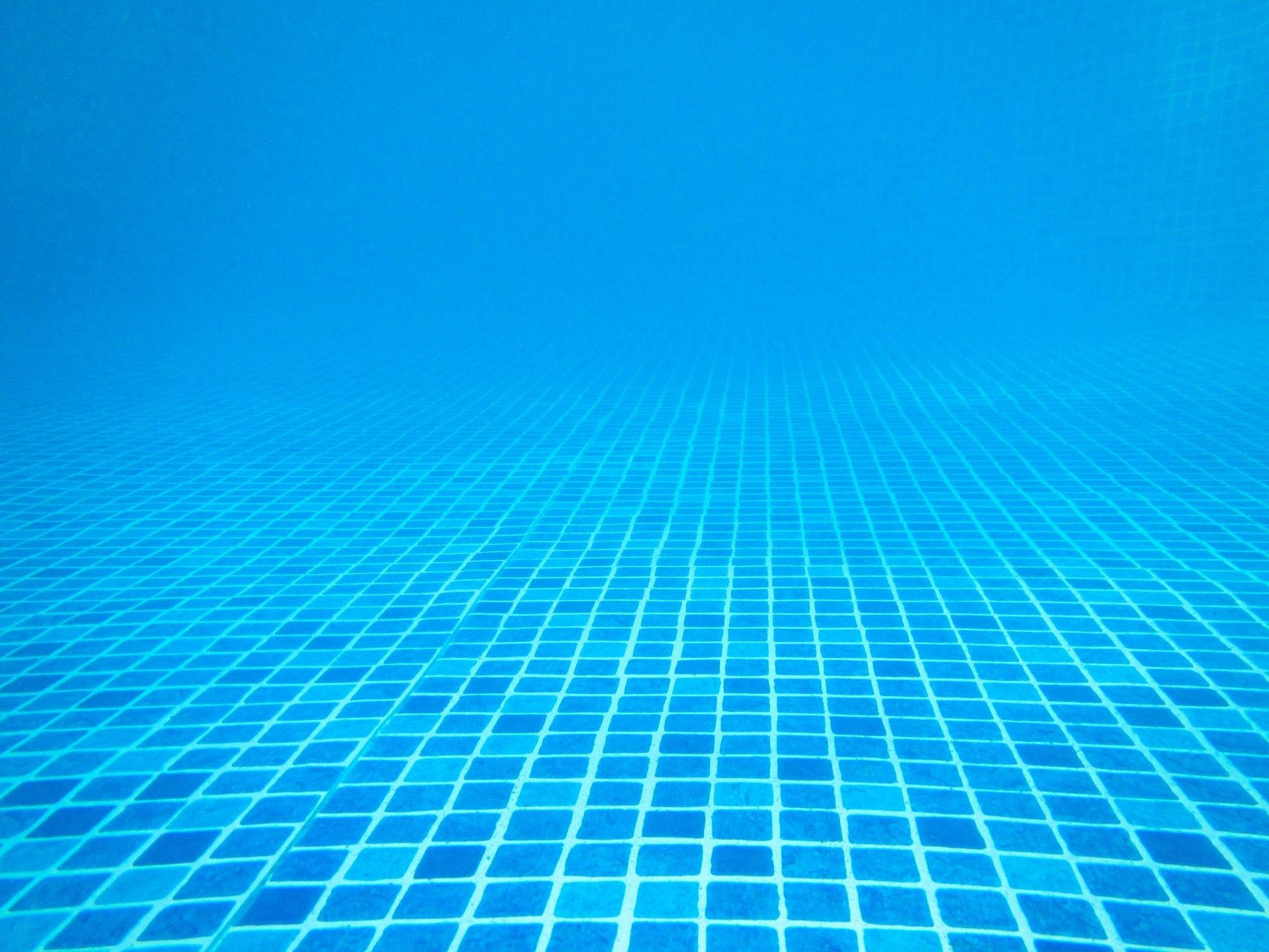 Swimming 桌布 壁紙 — 游泳池的藍色瓷磚逐漸消失在朦朧藍色水中的水下視圖。