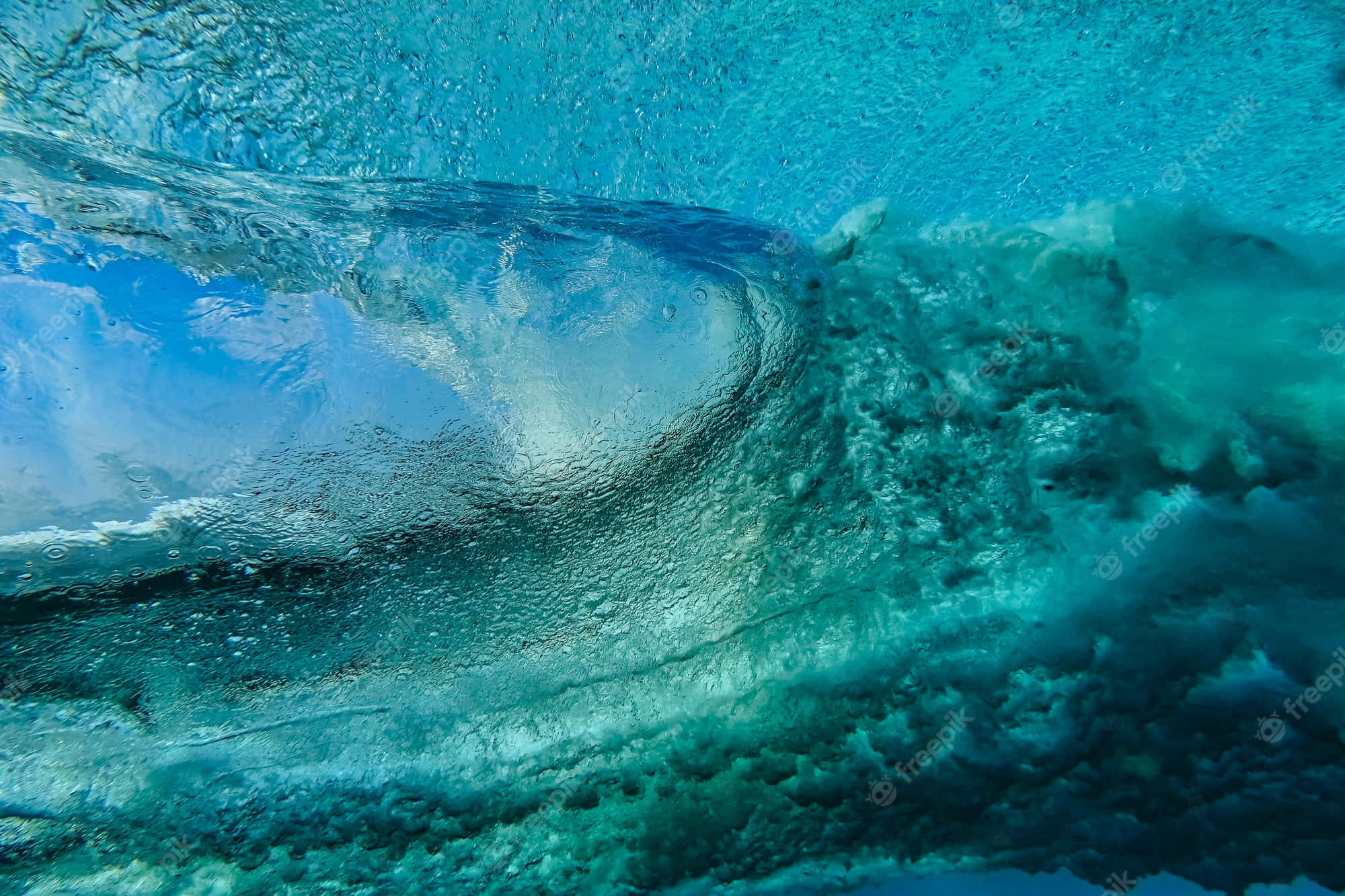 Underwater Ocean 桌布 壁紙 — 湍急藍綠色水中的水下景觀，帶有旋轉氣泡和紋理表面漣漪。