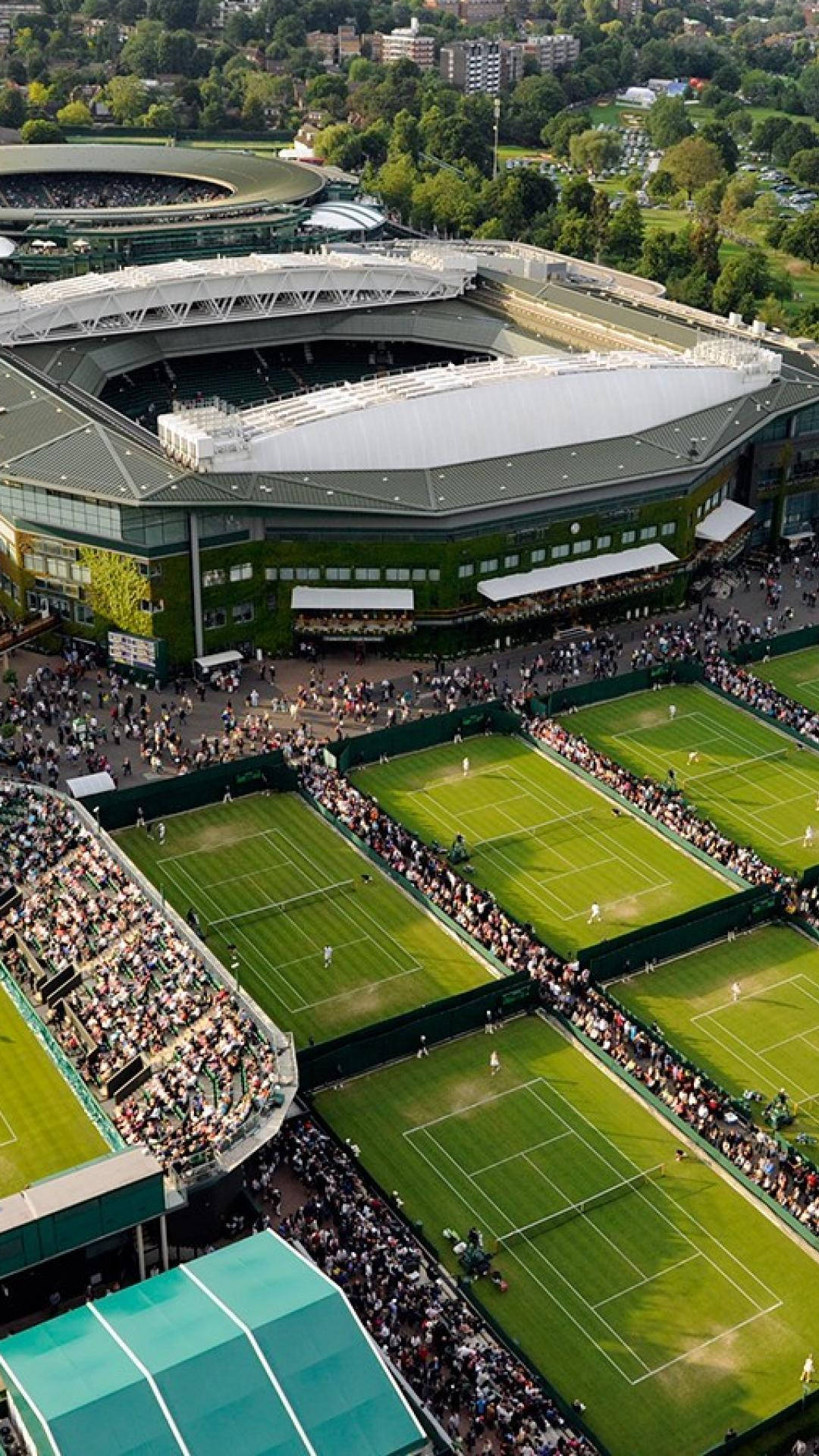 Wimbledon 桌布 壁紙 — 溫布頓網球場的鳥瞰圖，綠色球場在明亮的日光下擠滿了球員和人群。