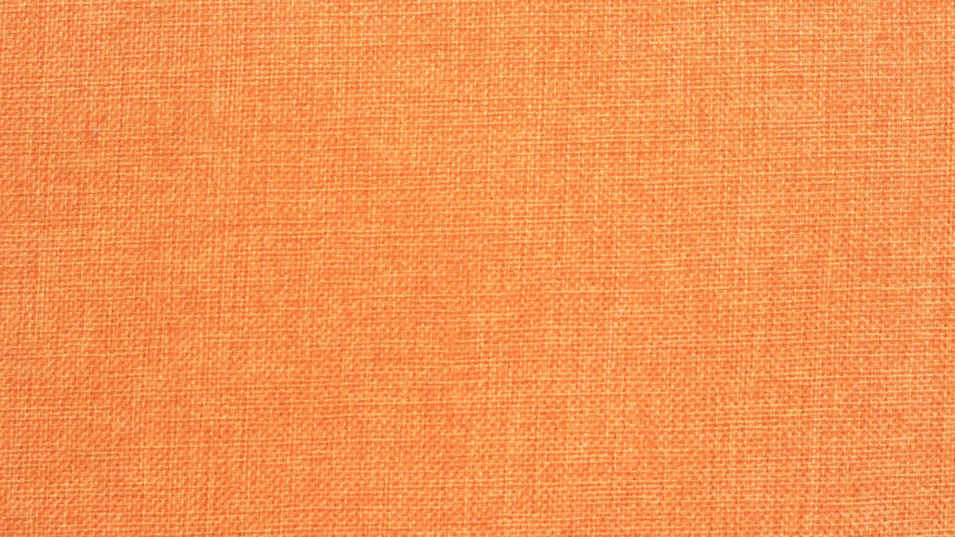Cute Orange 桌布 壁紙 — 溫暖橙色紋理布料的特寫，具有一致的編織圖案和柔和光線。