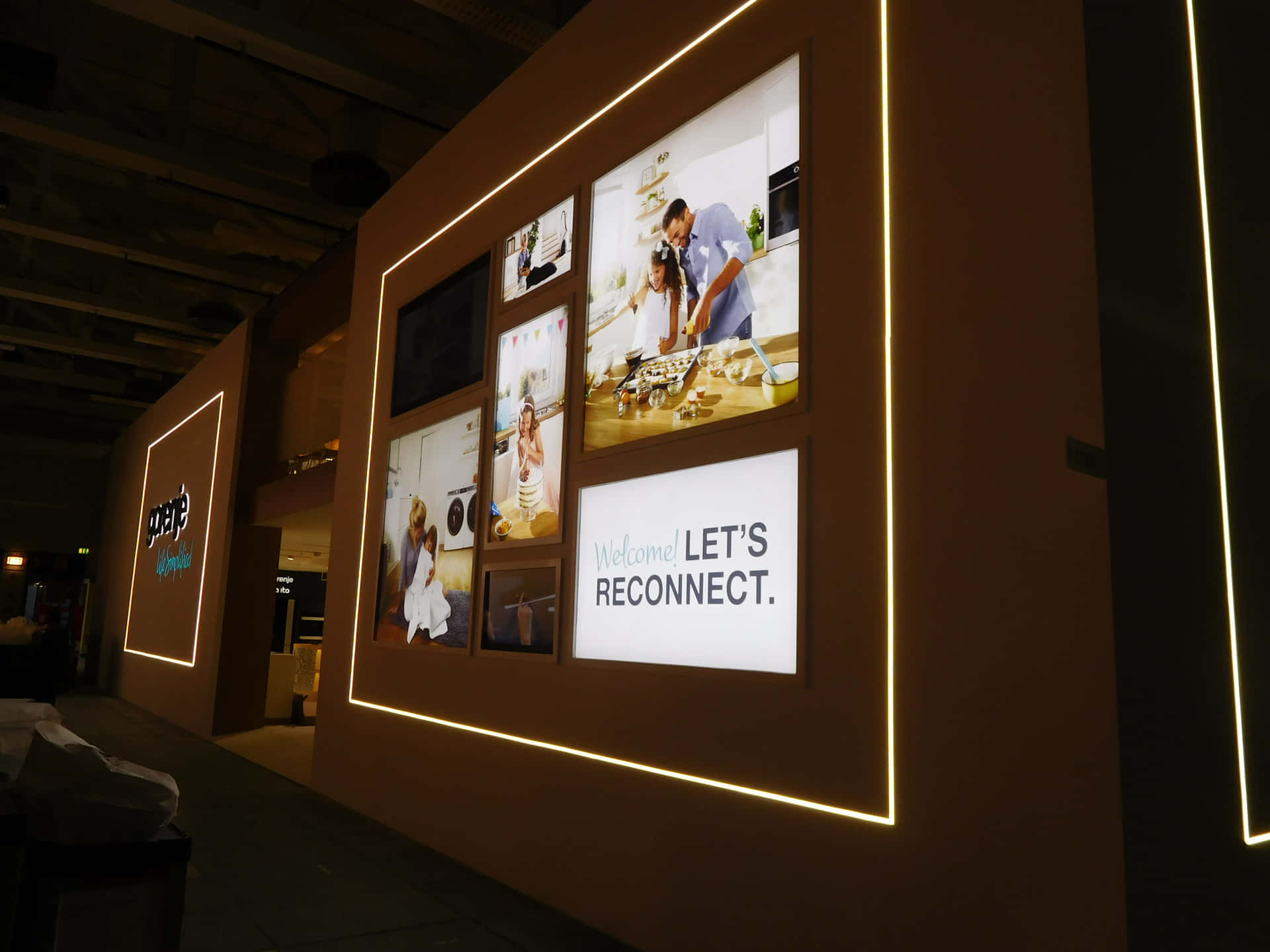 Exhibition 桌布 壁紙 — 溫暖照明的牆上展示家庭照片和一個「Let's Reconnect」標誌，位於現代室內空間。