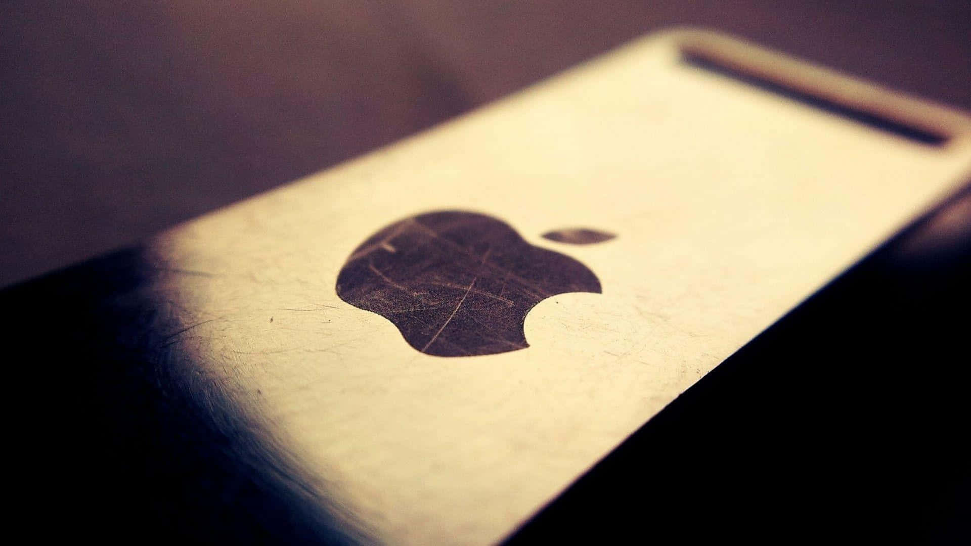 標誌 桌布 壁紙 — 溫暖燈光及淺景深下，復古智慧型手機上刮花的Apple標誌特寫。