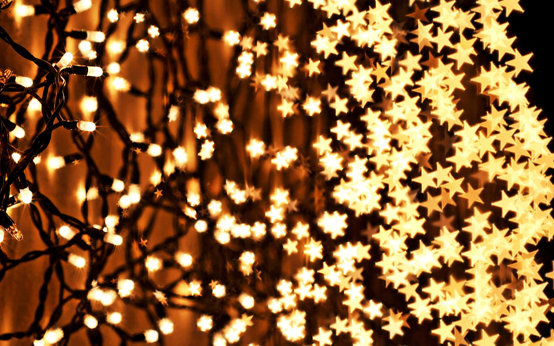 lights 桌布 壁紙 — 溫暖發光的星形燈光在黑暗背景上柔和焦點閃爍，營造出節日魔幻氛圍。