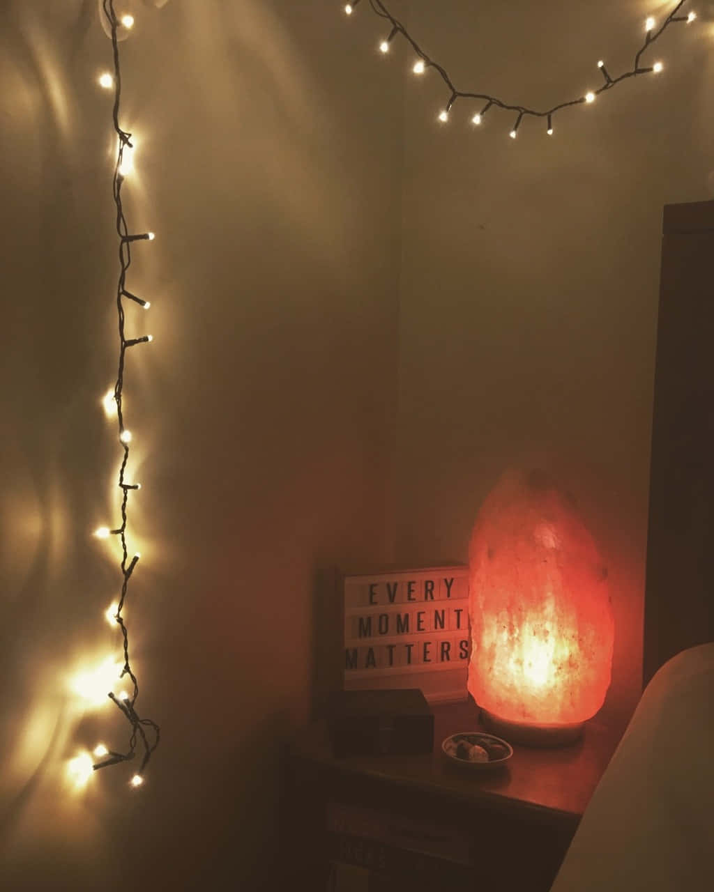 Aesthetic Cute Profile 桌布 壁紙 — 溫暖的串燈和發光的鹽燈在床邊舒適角落投射出柔和的琥珀色光芒，配以勵志標語牌。