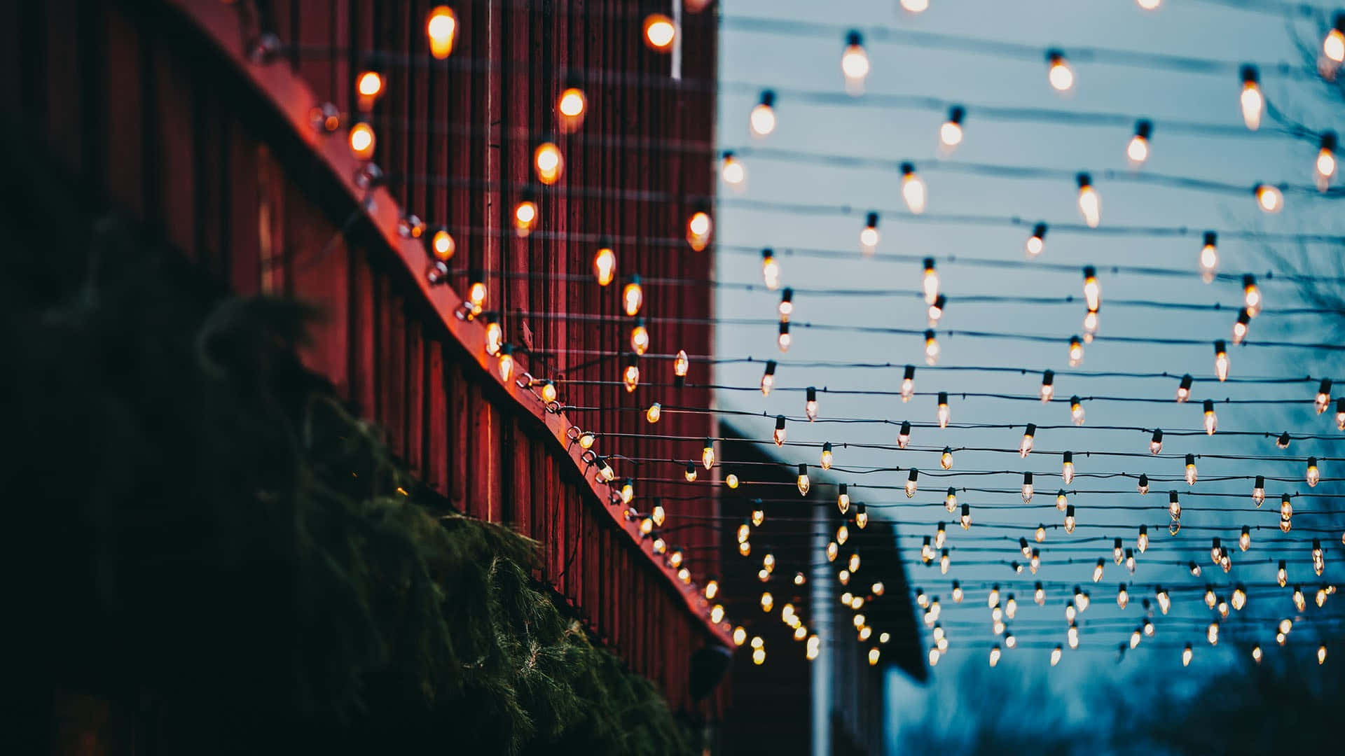 Light 桌布 壁紙 — 溫暖的串燈在昏暗的藍天下映照著紅色穀倉牆壁。