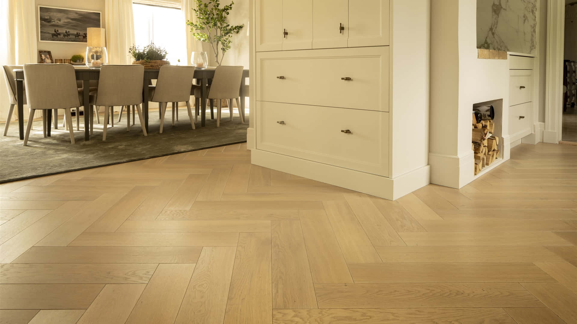 Wood Flooring 桌布 壁紙 — 溫暖的人字形橡木地板延伸穿過一個明亮的現代餐廳，配有奶油色櫥櫃和自然光。