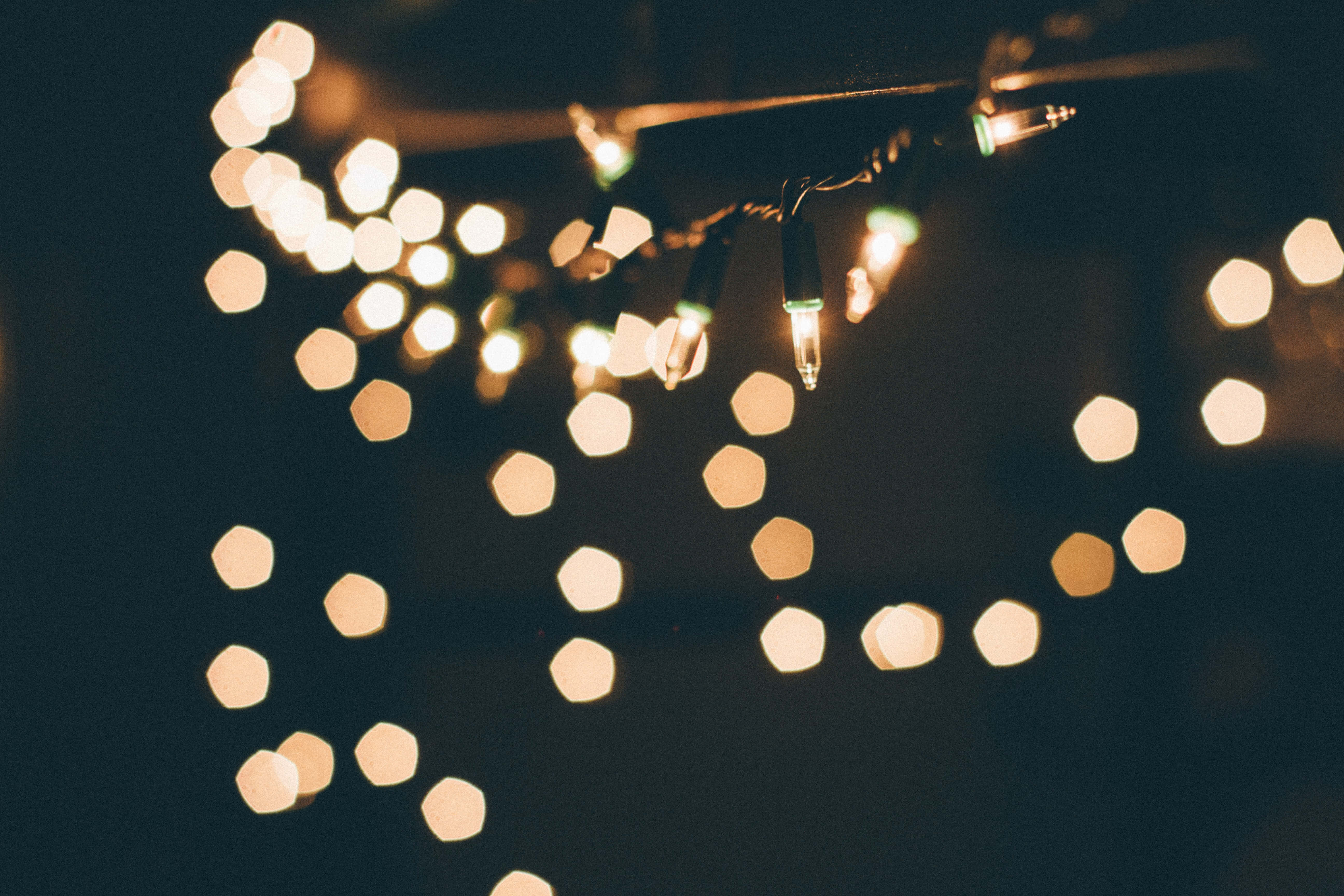Christmas Light 桌布 壁紙 — 溫暖的六角形散景燈光在黑暗背景上柔和發光，營造出舒適的節日氛圍。