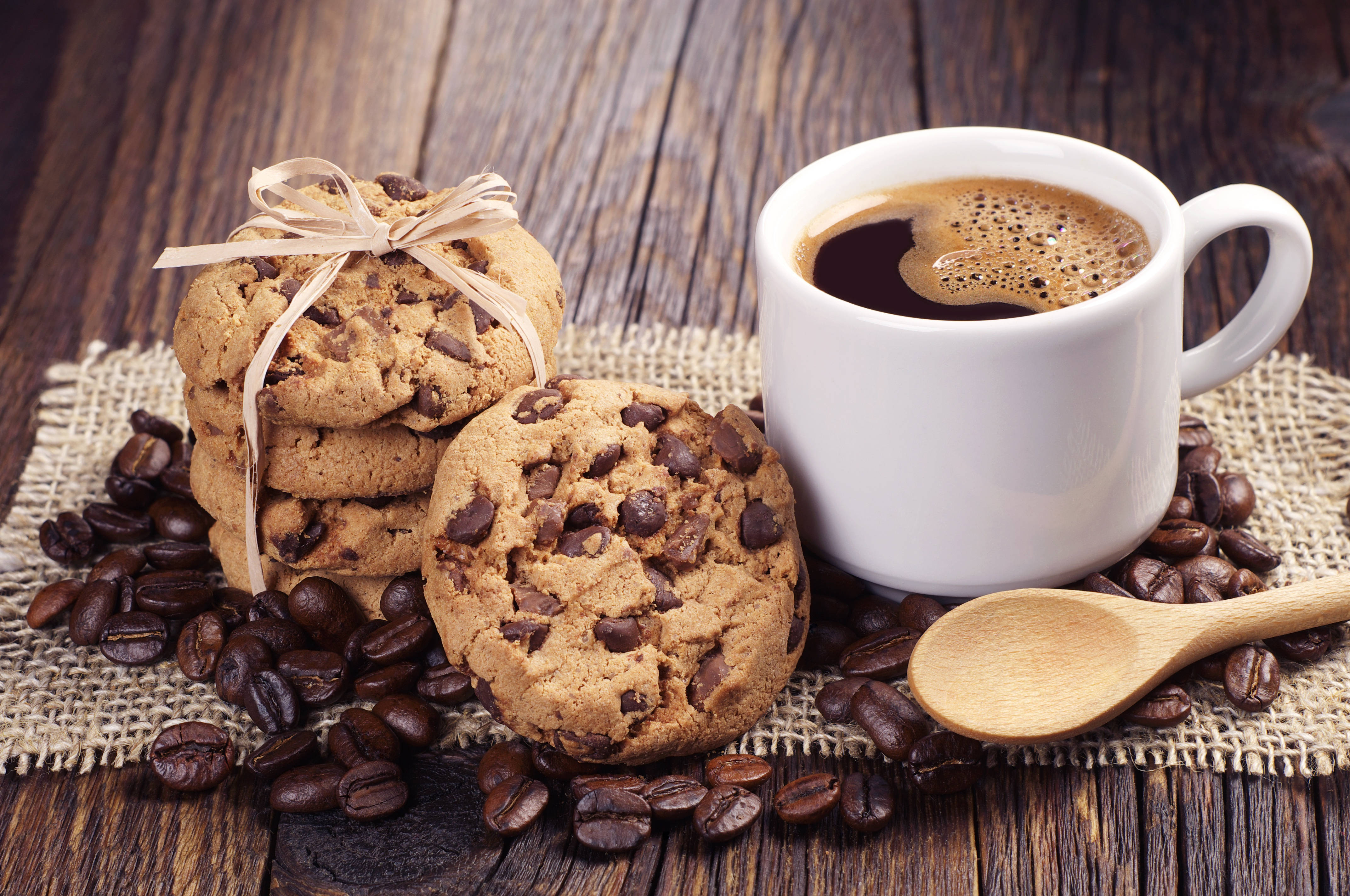 Cookies 桌布 壁紙 — 溫暖的巧克力餅乾和冒煙的咖啡杯，被咖啡豆圍繞在鄉村風木桌上。